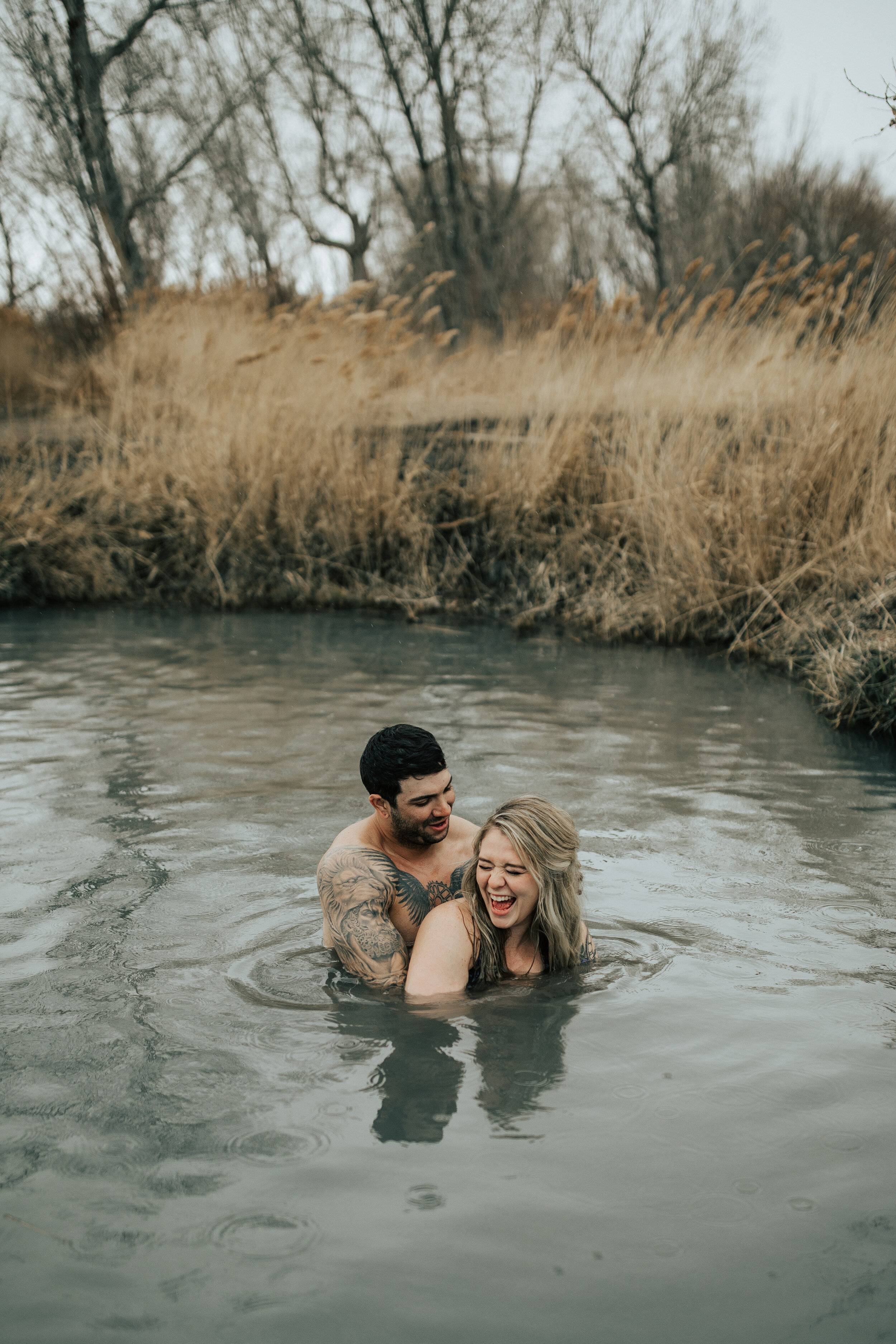 Couple laughing and playing in a pond, man holds woman, captured by Salt Lake City Photographer, Emily Jenkins. Couples in love unique couple poses park city photo shoot couple shoot couple in pond lovers couple photo ideas #utahcouplephotographer #