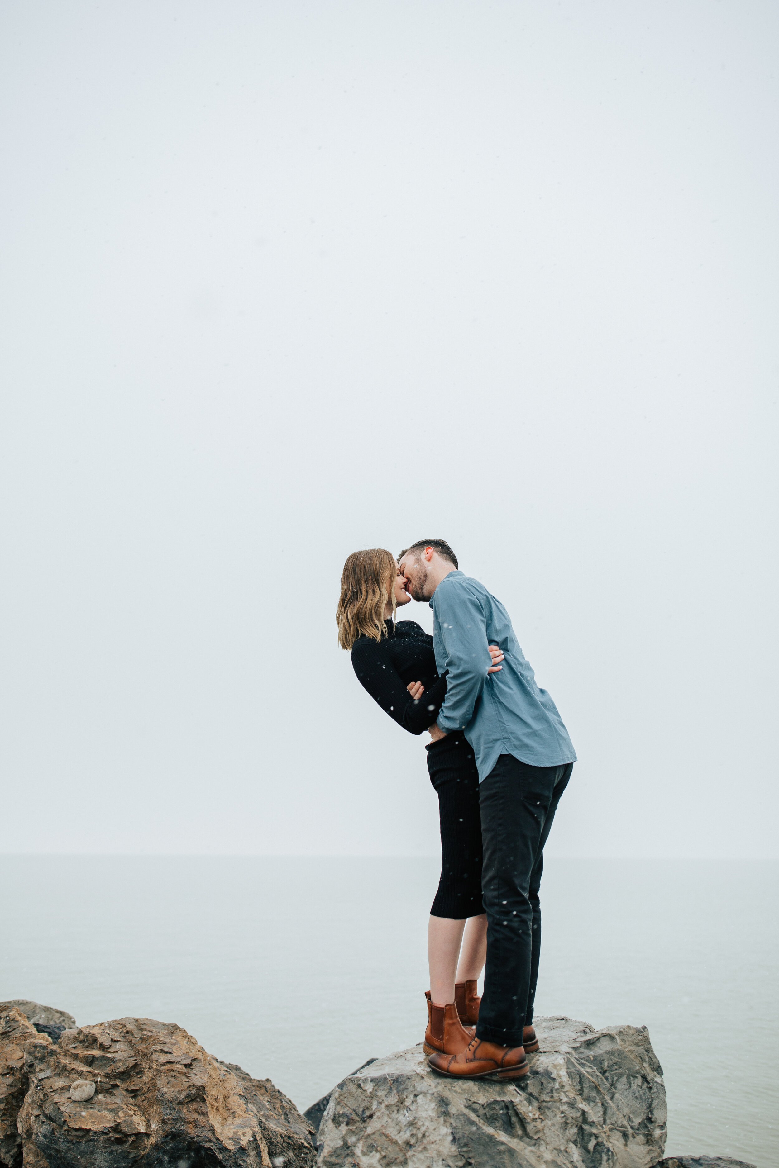  Salt Lake City Photographer Emily Jenkins captures a full body shot of a couple holding each other tight and kissing with beautiful monochromatic sky. Utah couple photo ideas professional utah photographer utah photo locations travel utah couple sty