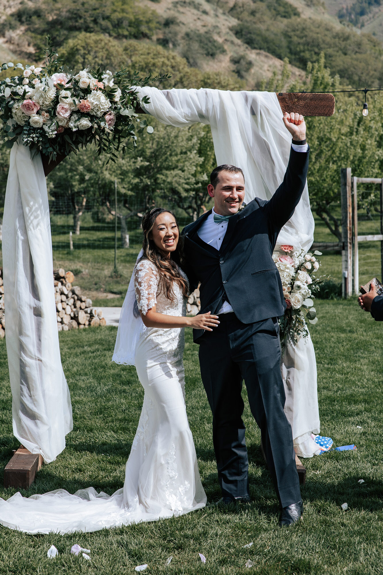  Husband raises his hand in a cheer after he marries his wife in Mapleton Utah by Professional wedding photographer Emily Jenkins Photography. husband cheers during marriage meadow wedding country wedding #emilyjenkinsphotography #emilyjenkinswedding