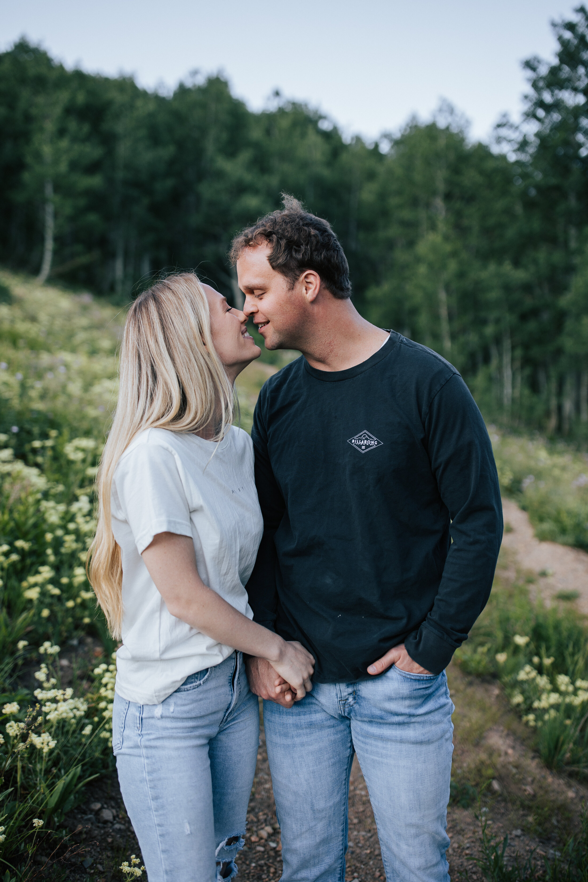  Engagement session in wildflowers in the mountains near Park City, Utah. Summertime engagement photos with mountain views. Engaged couple kiss in the mountains. Outfit inspo. Engagement outfits. #engagementphotos #engagements #weddingphotographer #p