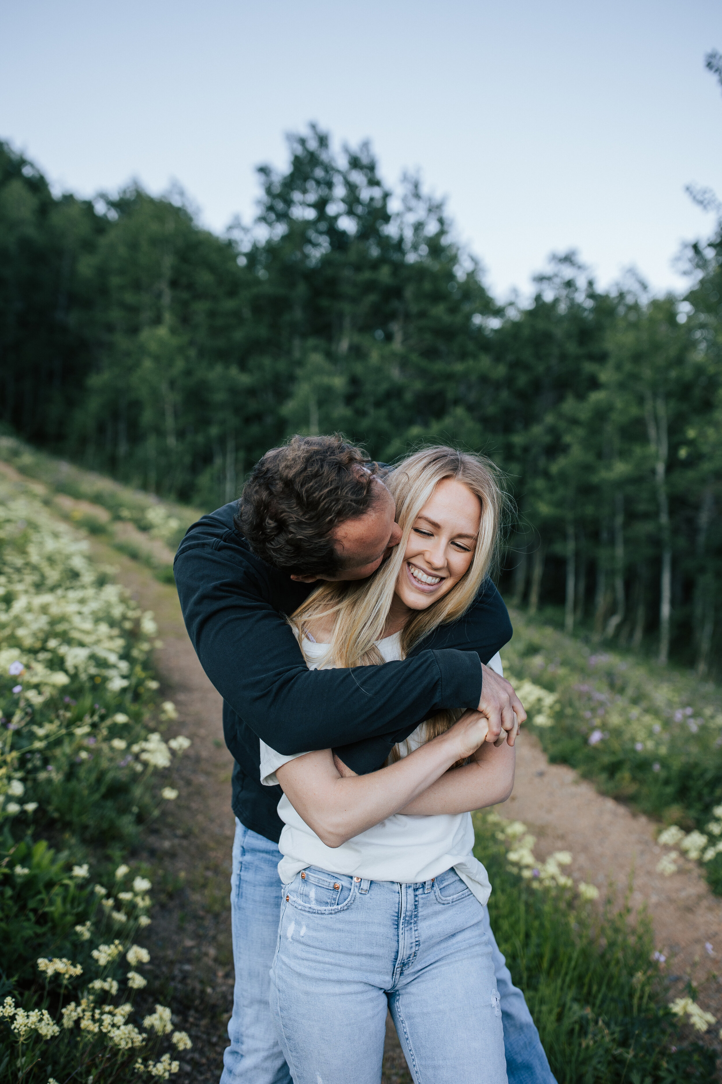  Engagement session in wildflowers in the mountains near Park City, Utah. Summertime engagement photos with mountain views. Engaged couple walk through wildflowers in the mountains. #engagementphotos #engagements #weddingphotographer #photographer #p