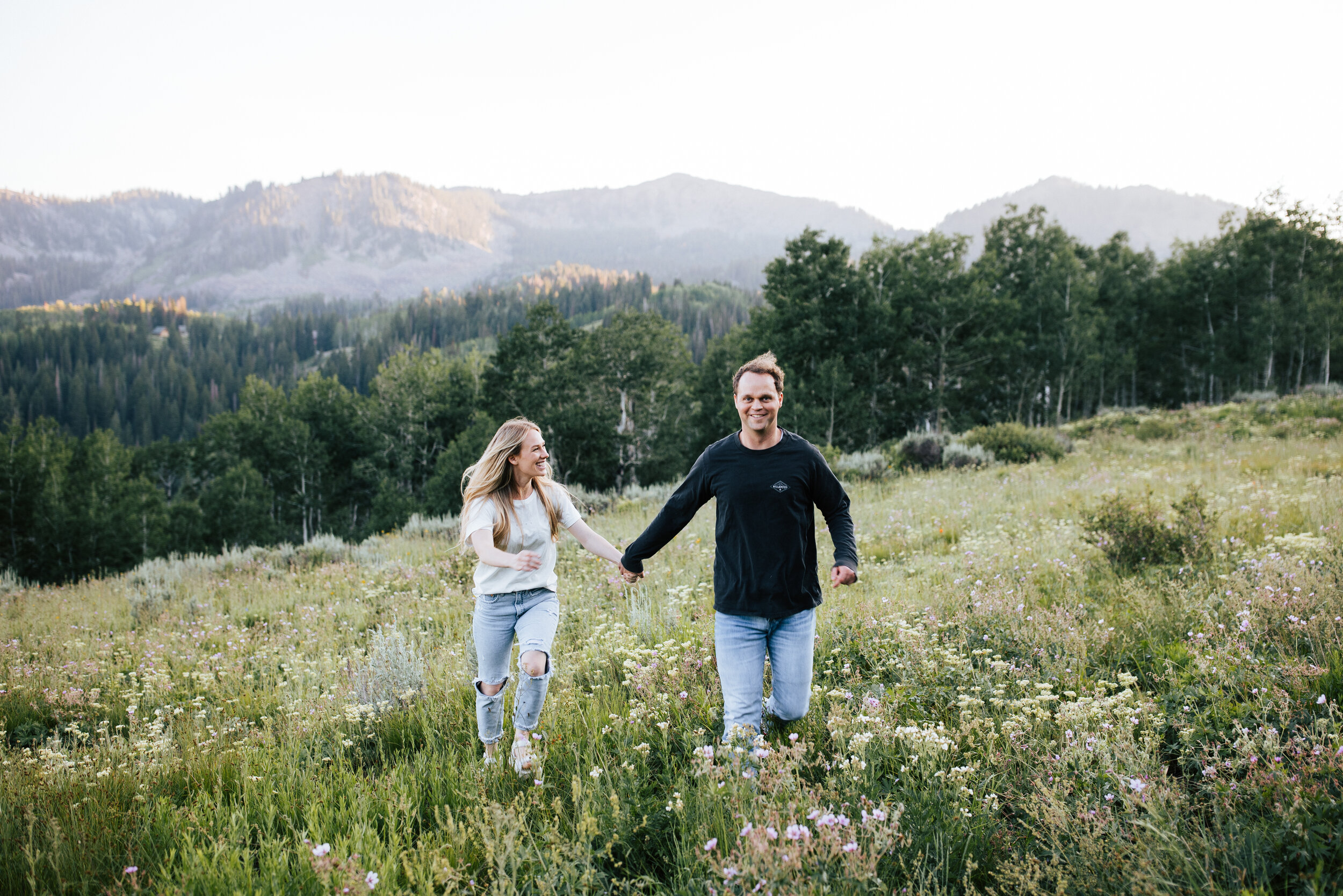  Engagement session in wildflowers in the mountains near Park City, Utah. Summertime engagement photos with mountain views. Engaged couple running around in the mountains. Outfit inspo. Engagement outfits. #engagementphotos #engagements #weddingphoto