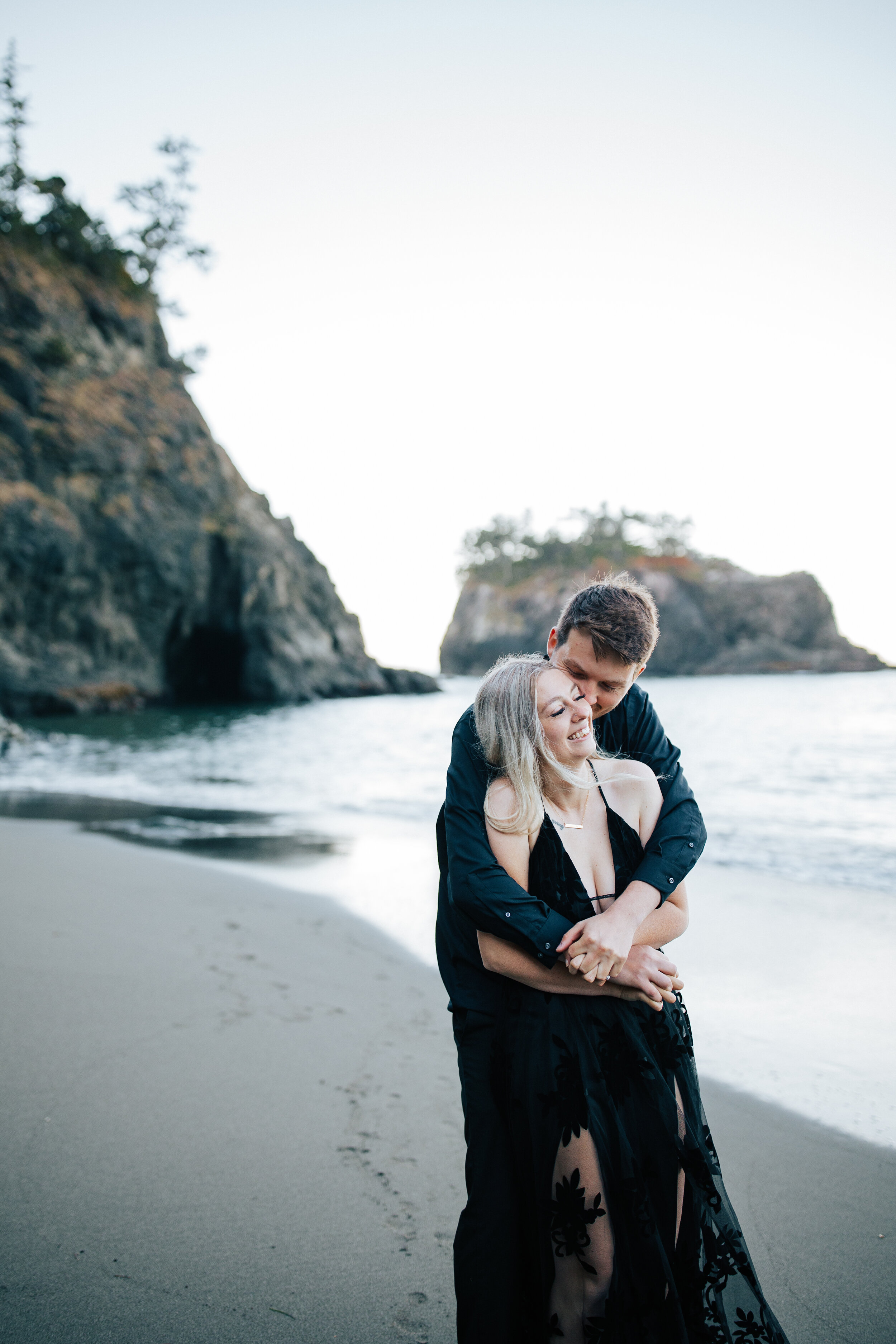  Samuel H Boardman Scenic Corridor southern Oregon coast elopement bride and groom saying their vows on a cliff on the Oregon coast with sea stacks and the ocean below black bridal gown couple in all black a groom holds his new bride as they walk on 