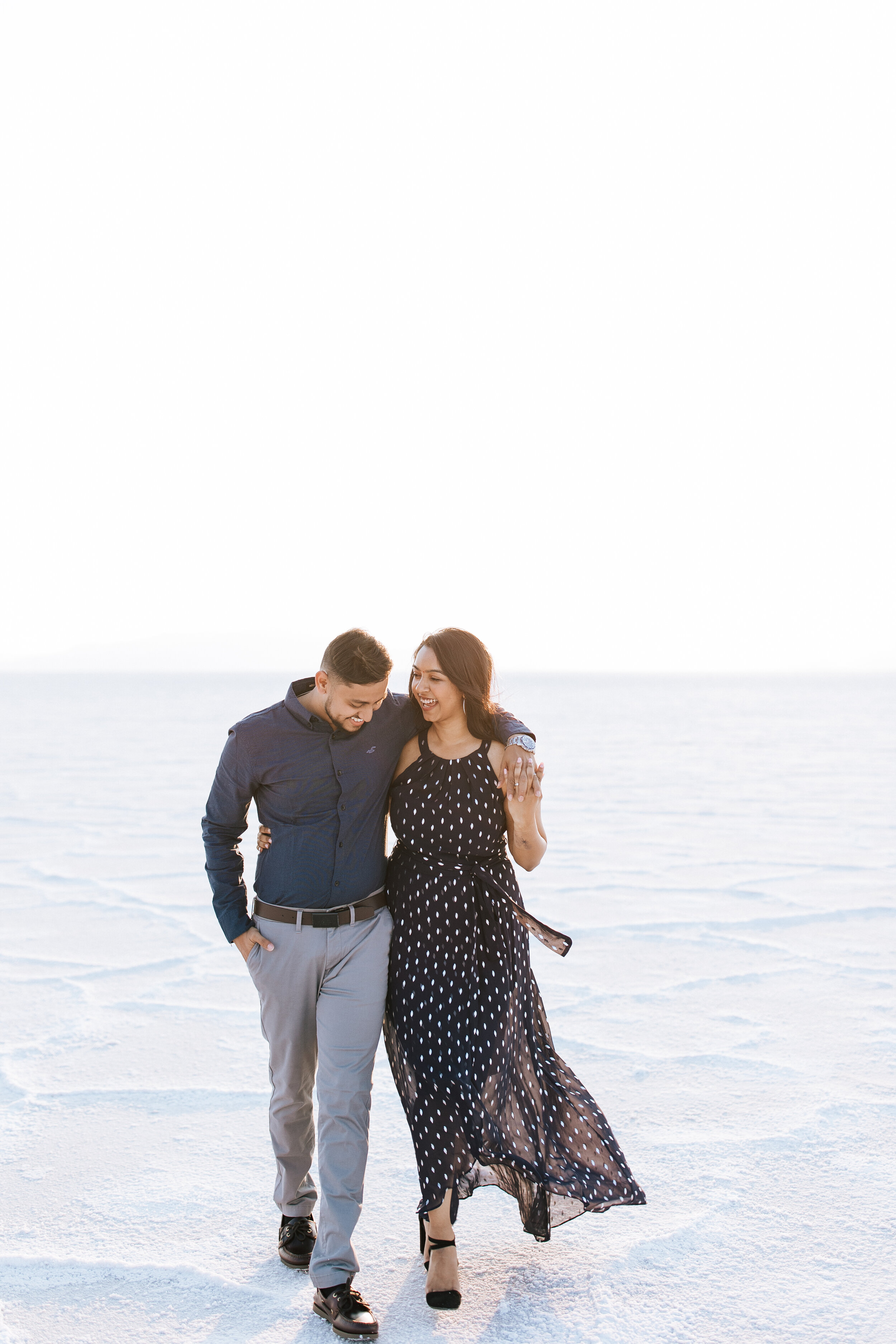  Engagement session at Bonneville Salt Flats near Salt Lake City, Utah. Couple walks across the Salt Flats near Wendover. Summer engagement shoot in Utah. Engagement shoot locations in Utah. Best places for engagement photos in Utah. Engagement outfi