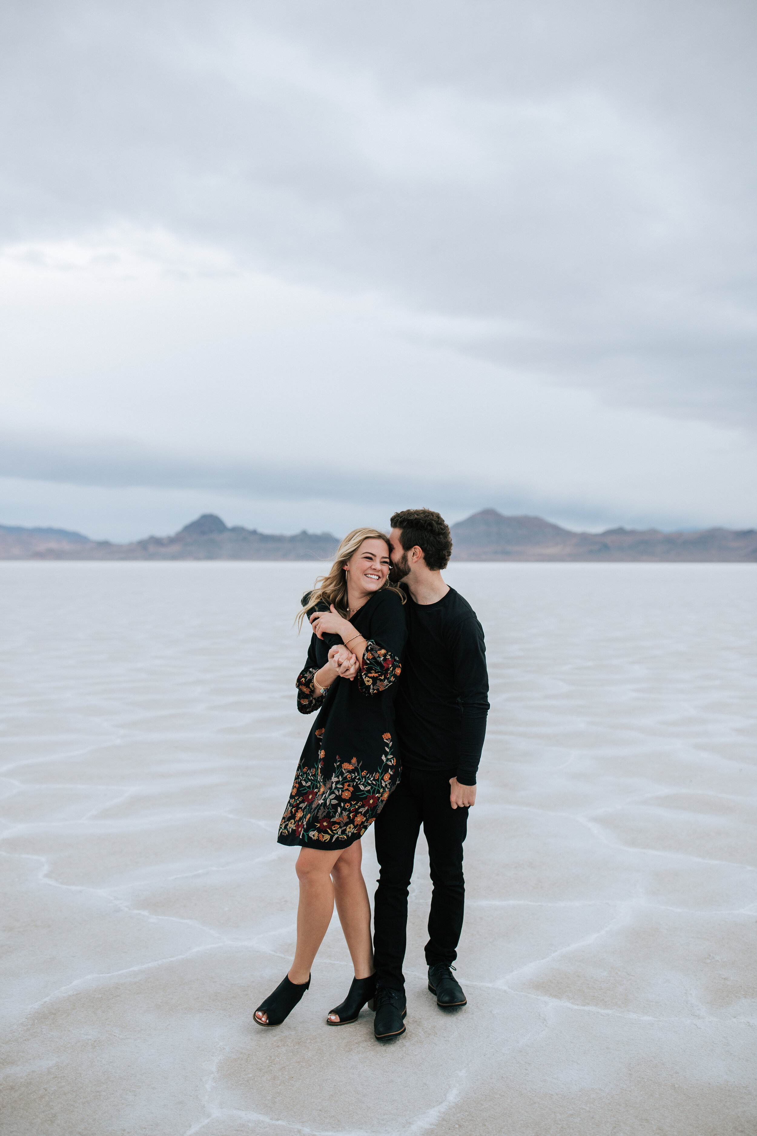  Engagement session at Bonneville Salt Flats near Salt Lake City, Utah. Couple walks across the Salt Flats near Wendover. Fun laughing couple shoot Summer engagement shoot in Utah. Engagement shoot locations in Utah. Best places for engagement photos