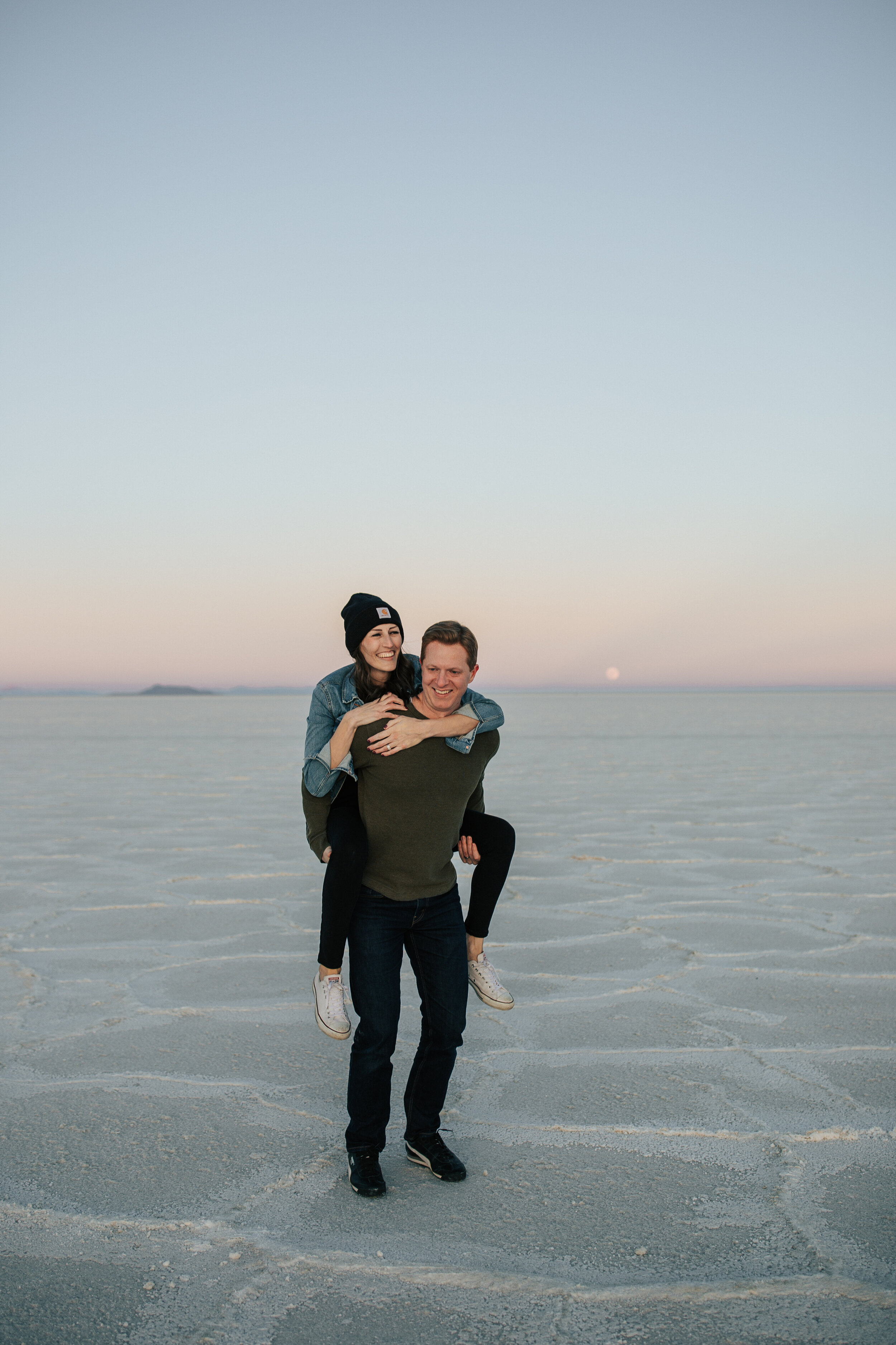  Engagement session at Bonneville Salt Flats near Salt Lake City, Utah. Couple walks across the Salt Flats near Wendover. Summer engagement shoot in Utah. Engagement shoot locations in Utah. Best places for engagement photos in Utah. Engagement outfi