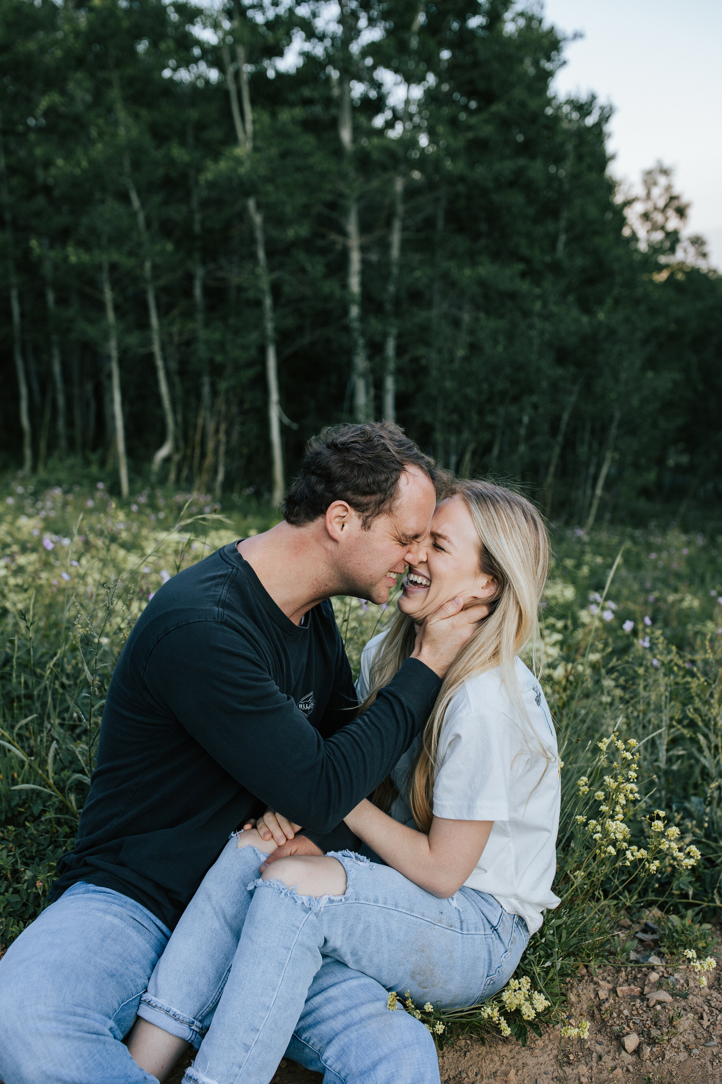  Tips for your couples session in Utah, a newly engaged couple has a tickle fight during a couples shoot in the mountains. Couple wearing casual clothes for their adventurous photoshoot. How to prepare for a couples session with Emily Jenkins Photo. 