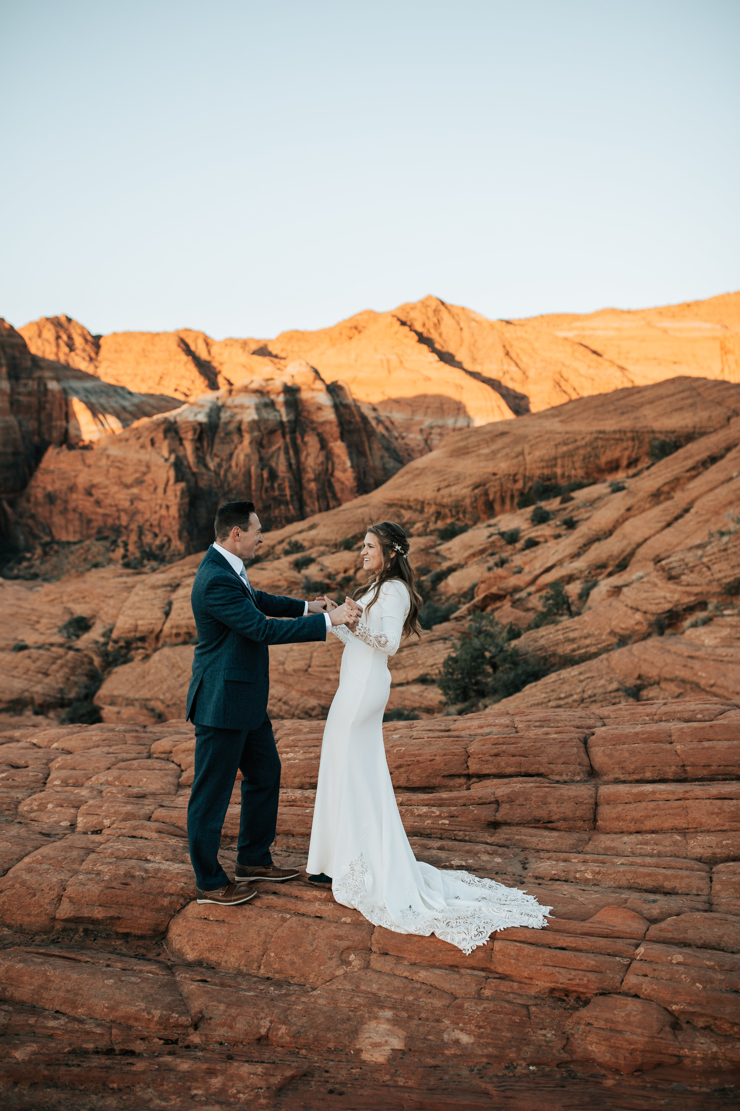  Husband and wife dance in wedding dress and suit on top of the red rocks in Southern Utah during an elopement with Emily Jenkins Photography. southern Utah elopement locations dancing wedding pictures elopement style #emilyjenkinsphotography #emilyj