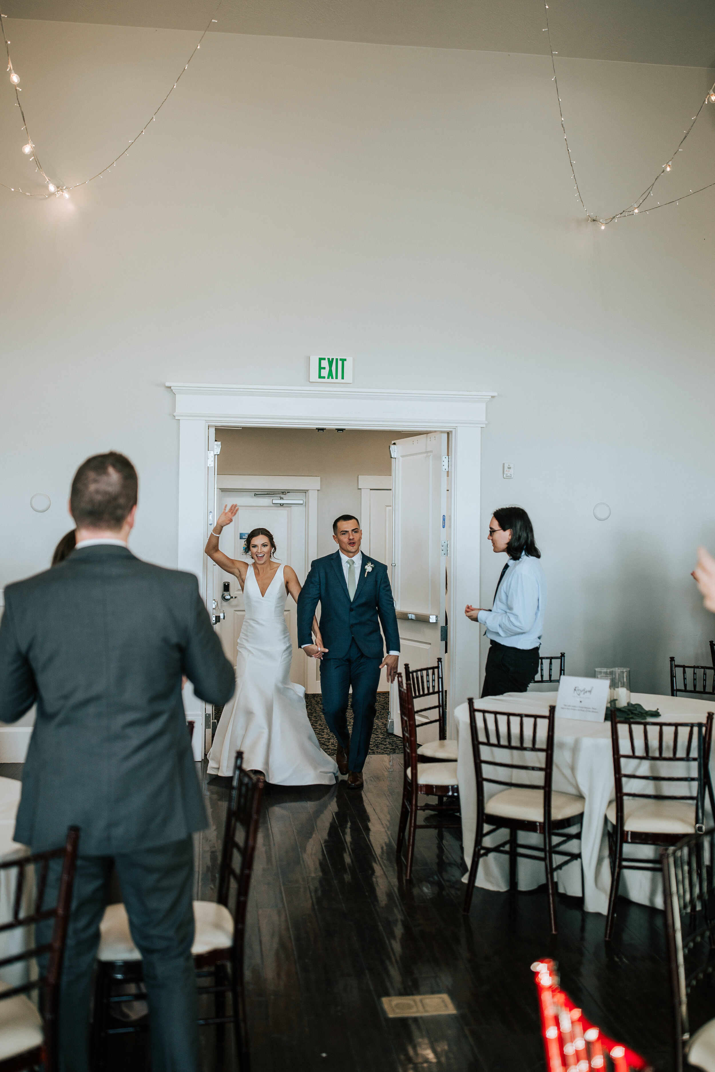  Bride and groom cheer as they enter the room at Sleepy Ridge Golf Course by wedding photographer Emily Jenkins Photography in Utah County. bride and groom enter room plunge neck wedding gown sleek dress #emilyjenkinsphotography #emilyjenkinsweddings