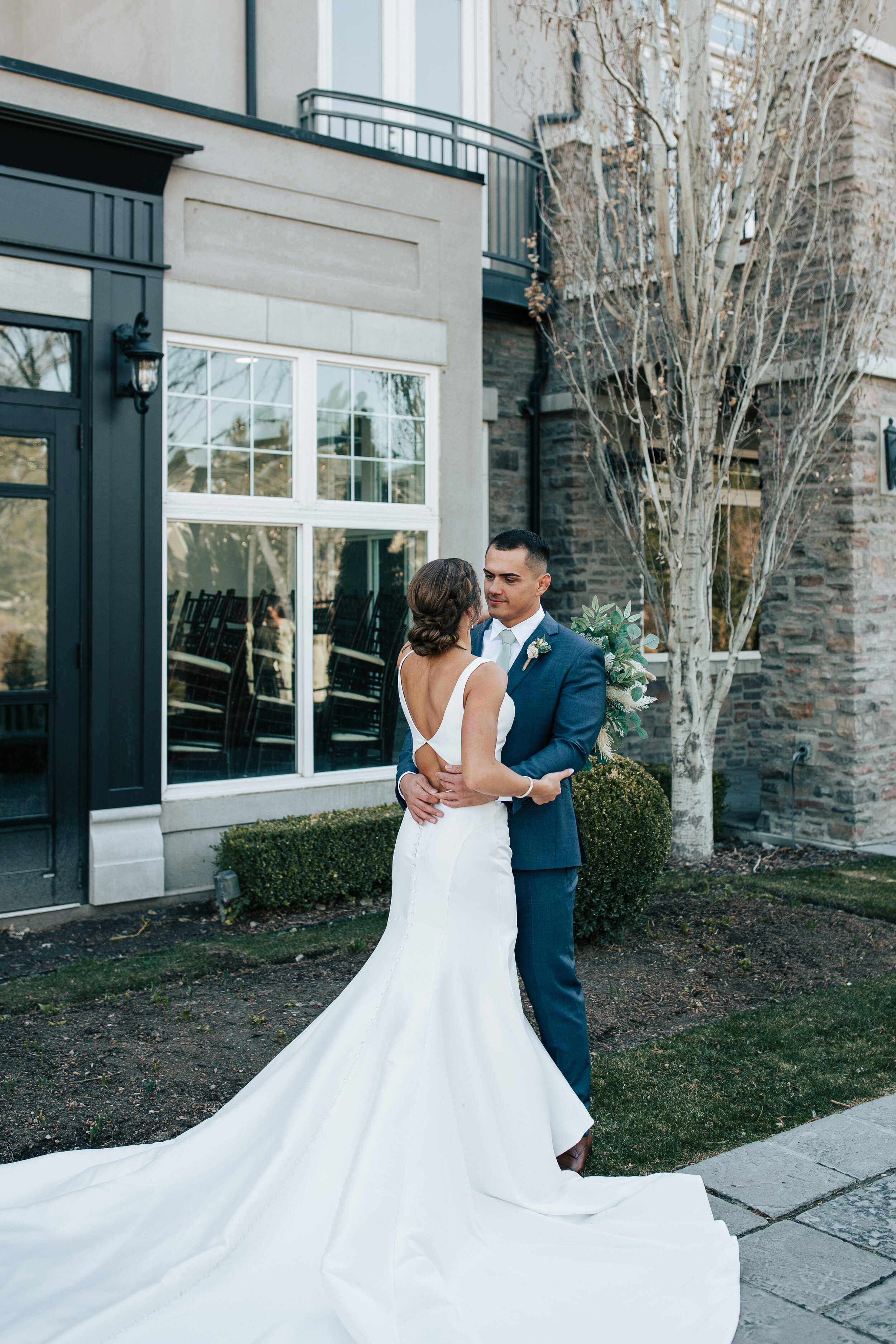  Outside of Sleepy Ridge Golf Course a groom wraps his arms around his bride and holds her tightly by Emily Jenkins Photography. sleepy ridge weddings bride and groom bridal gown train fan #emilyjenkinsphotography #emilyjenkinsweddings #utahcounty #s