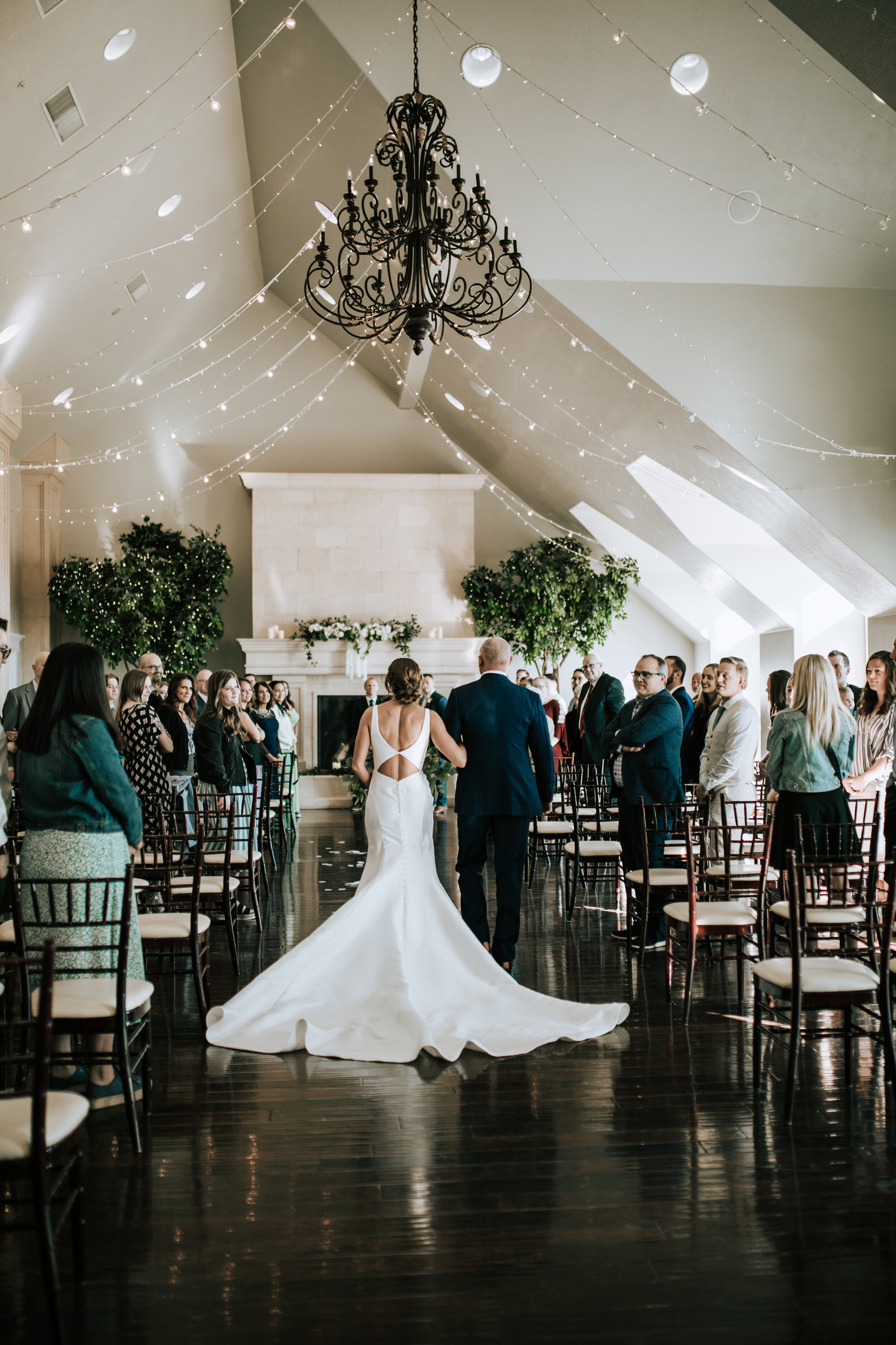  Father walks a bride down the aisle at Sleepy Ridge Golf Course with a tall ceiling with a chandelier and little lights hanging from the ceiling by Emily Jenkins Photography. bride walks down the aisle here comes the bride #emilyjenkinsphotography #