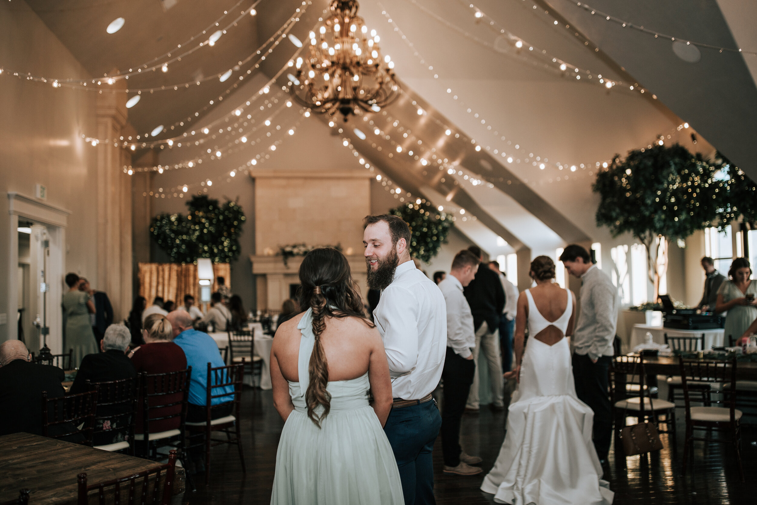  Wedding guests enjoy the party under fairy lights at Sleepy Ridge Golf Course in Orem, Utah captured by Professional wedding photographer Emily Jenkins Photography. wedding guest detail shot indoor utah county wedding venue #emilyjenkinsphotography 
