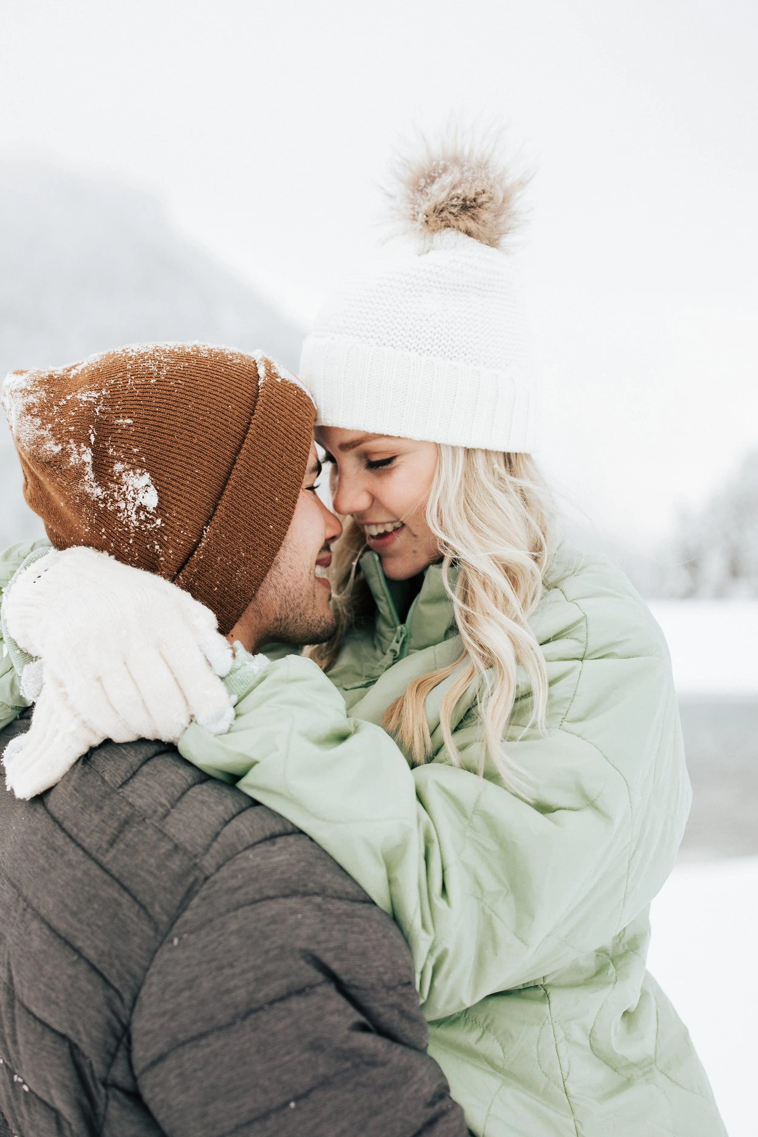  Snowball fight during couples photoshoot in the Utah mountains couple hugs as it's snowing covered in snowflakes engagement session winter outfit inspo #outfitinspo #parkcityphotographer #engagements #winterengagements 