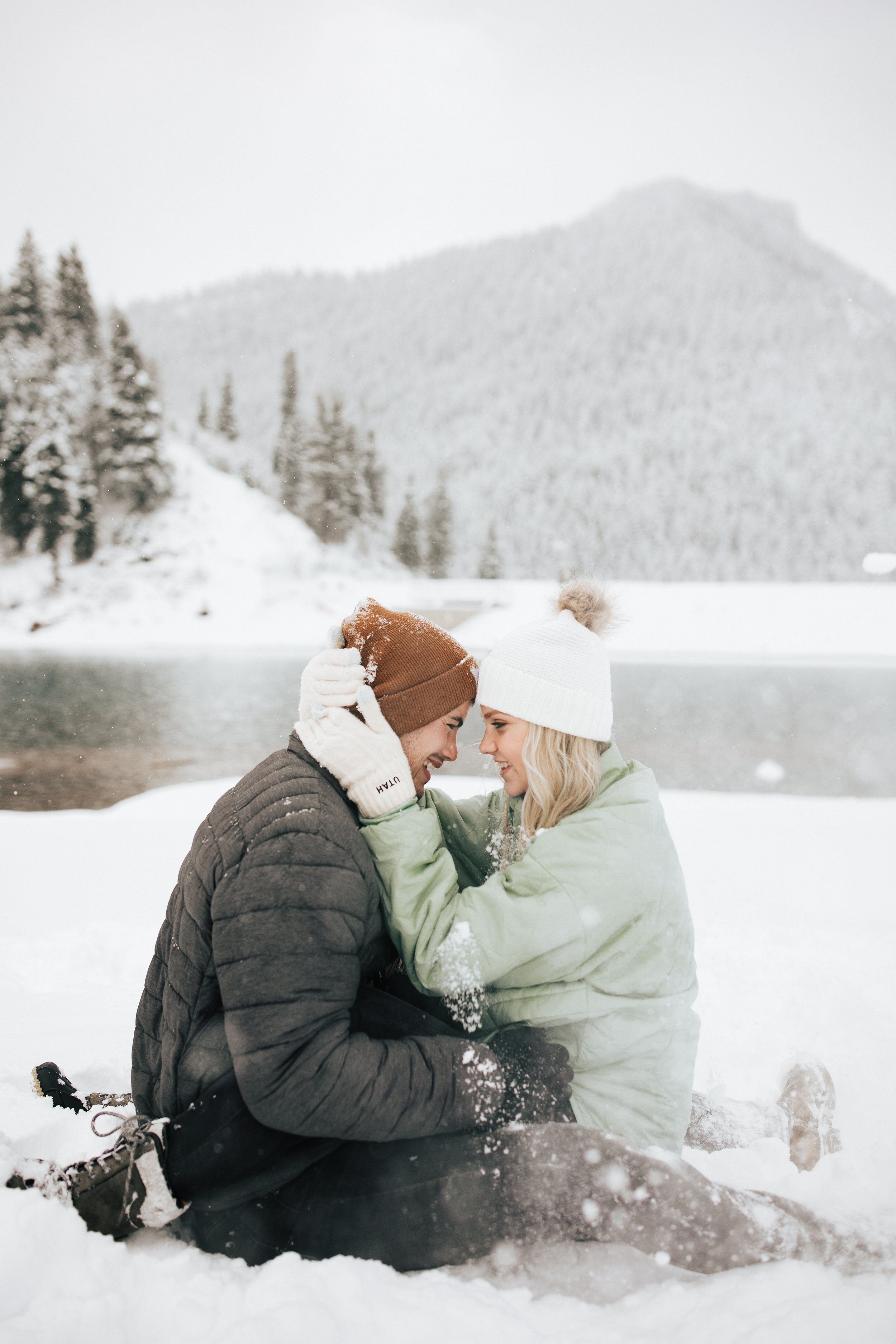  Snowball fight during couples photoshoot in the Utah mountains couple hugs as it's snowing covered in snowflakes engagement session winter outfit inspo #outfitinspo #parkcityphotographer #engagements #winterengagements 