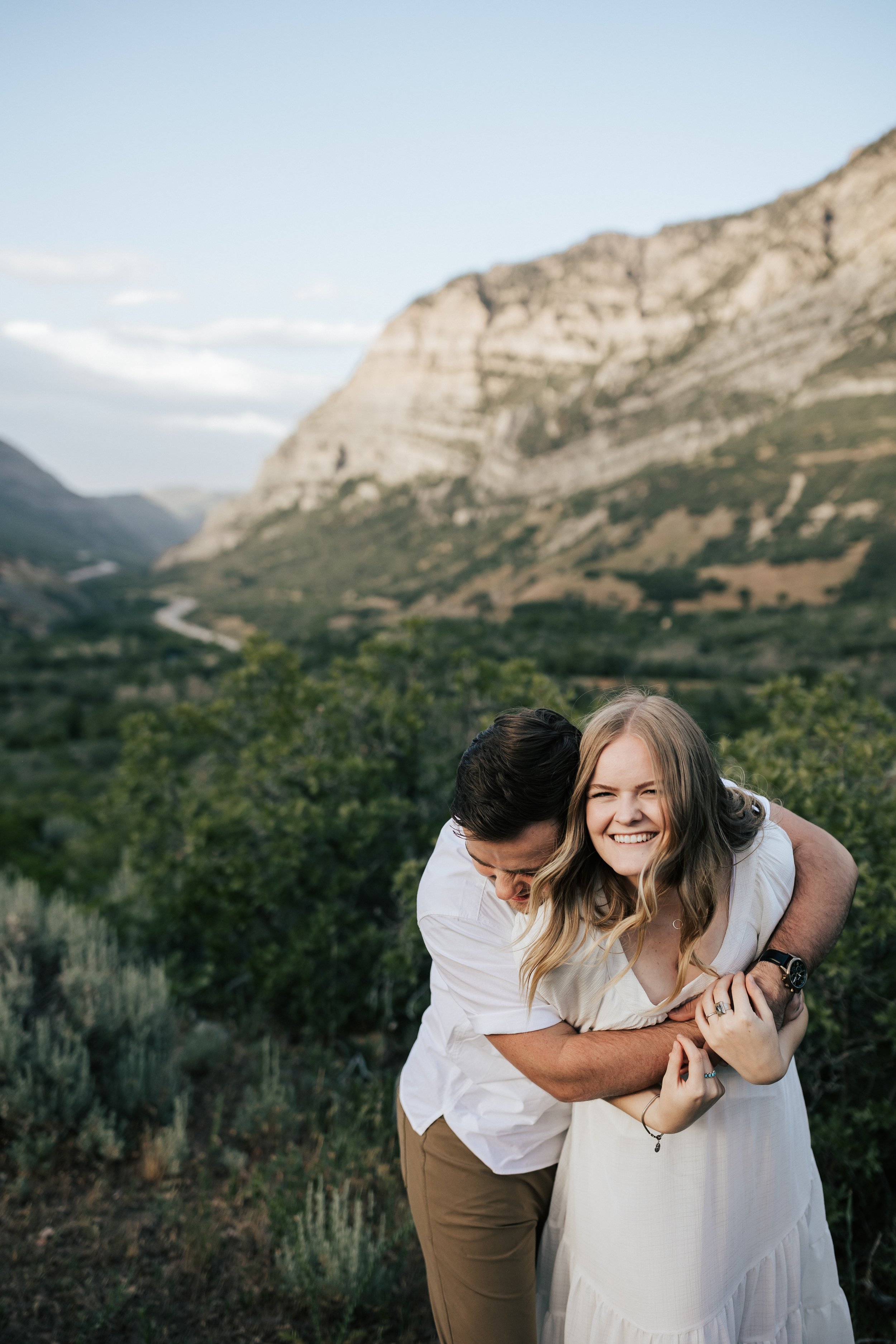  Summer anniversary couples session in the mountains. A young couple tickles each other in the mountains. Utah photographer. Engagement session. #utahphotographer #utahengagements  