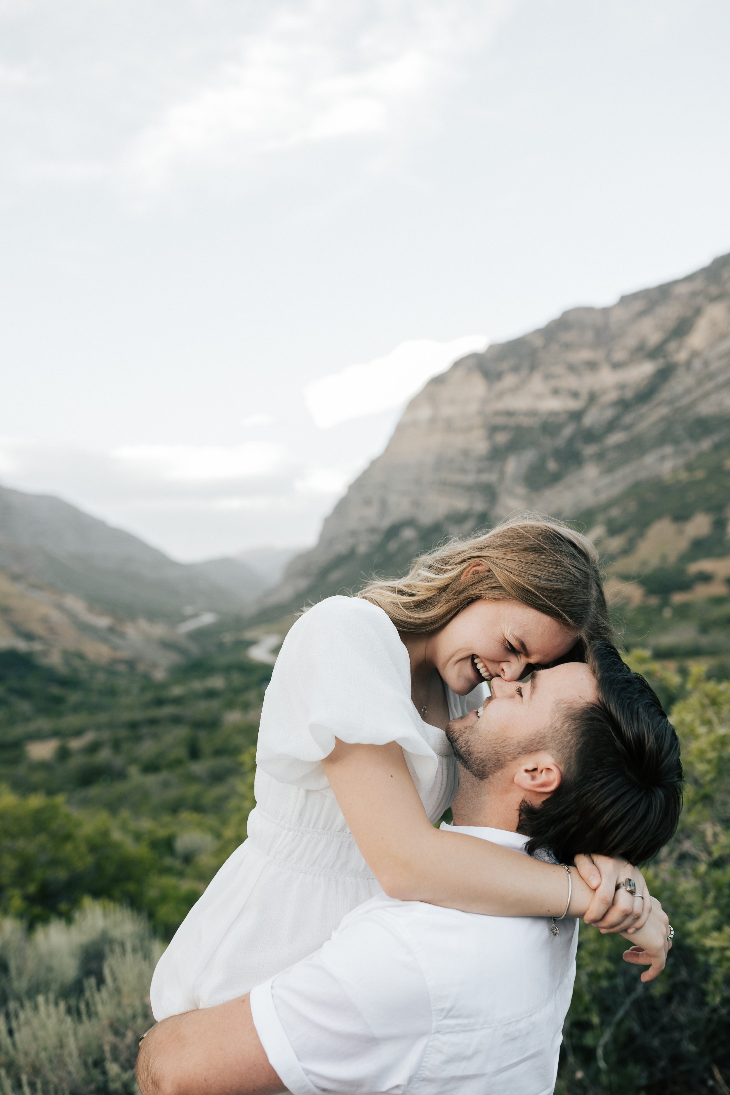  Summer anniversary couples session in the mountains. A young couple holds each other while kissing in the mountains. Utah photographer. Engagement session. #utahphotographer #utahengagements  