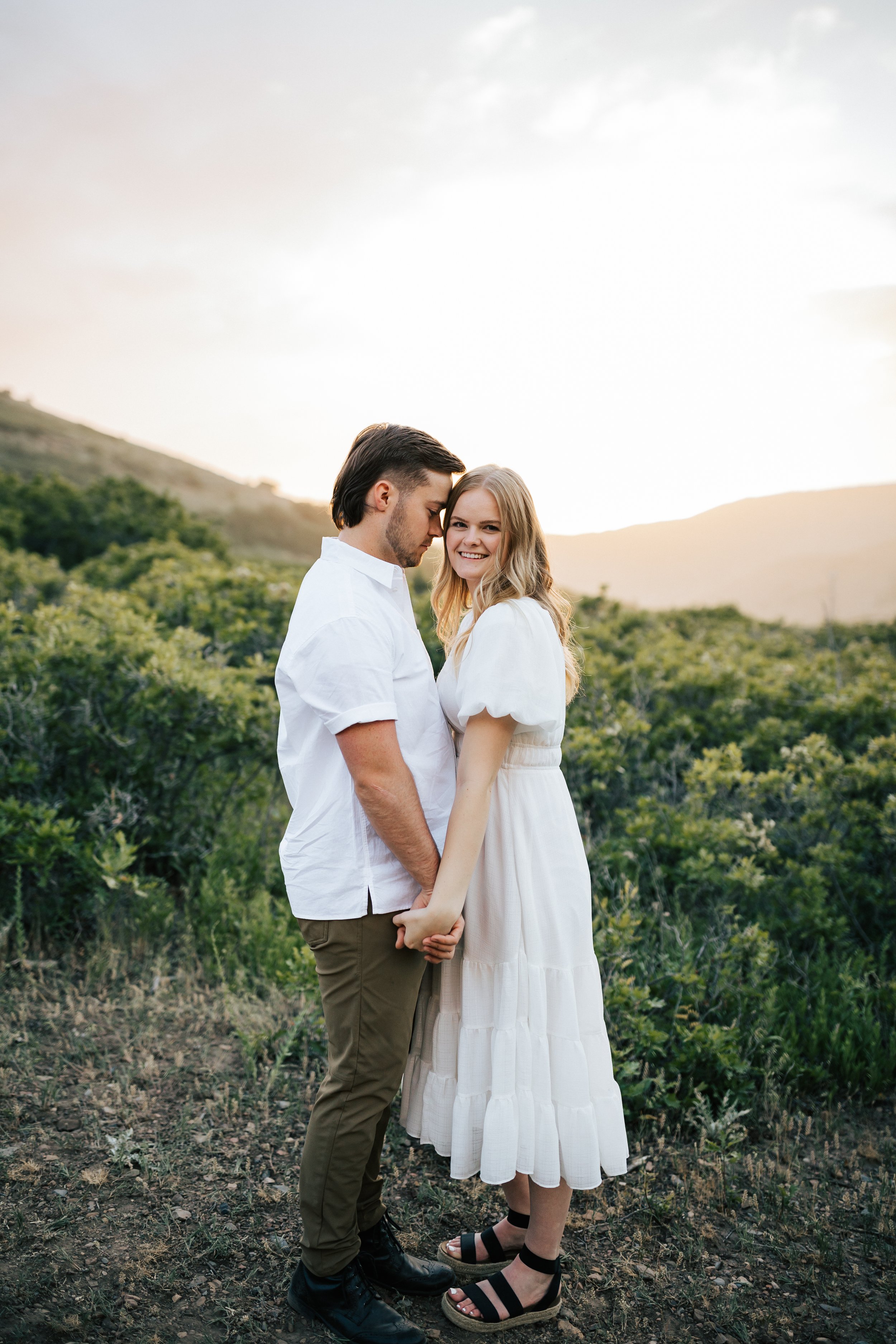  Summer anniversary couples session in the mountains. A young couple laughs together with the sun shining behind them. Utah photographer. #utahphotographer #utahengagements  