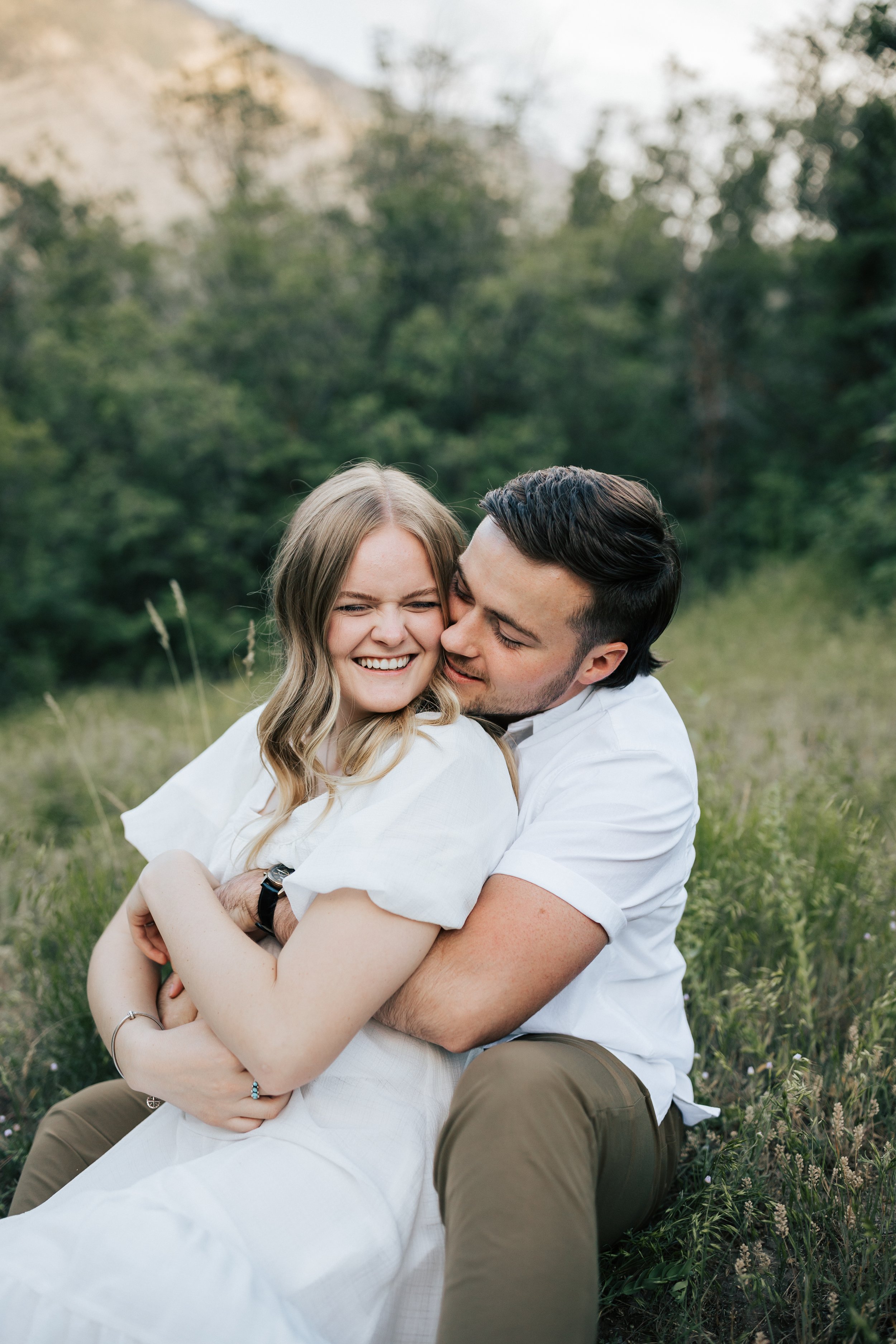  Summer anniversary couples session in the mountains. A young couple cuddles in the tall grass in the mountains. Utah photographer. #utahphotographer #utahengagements  