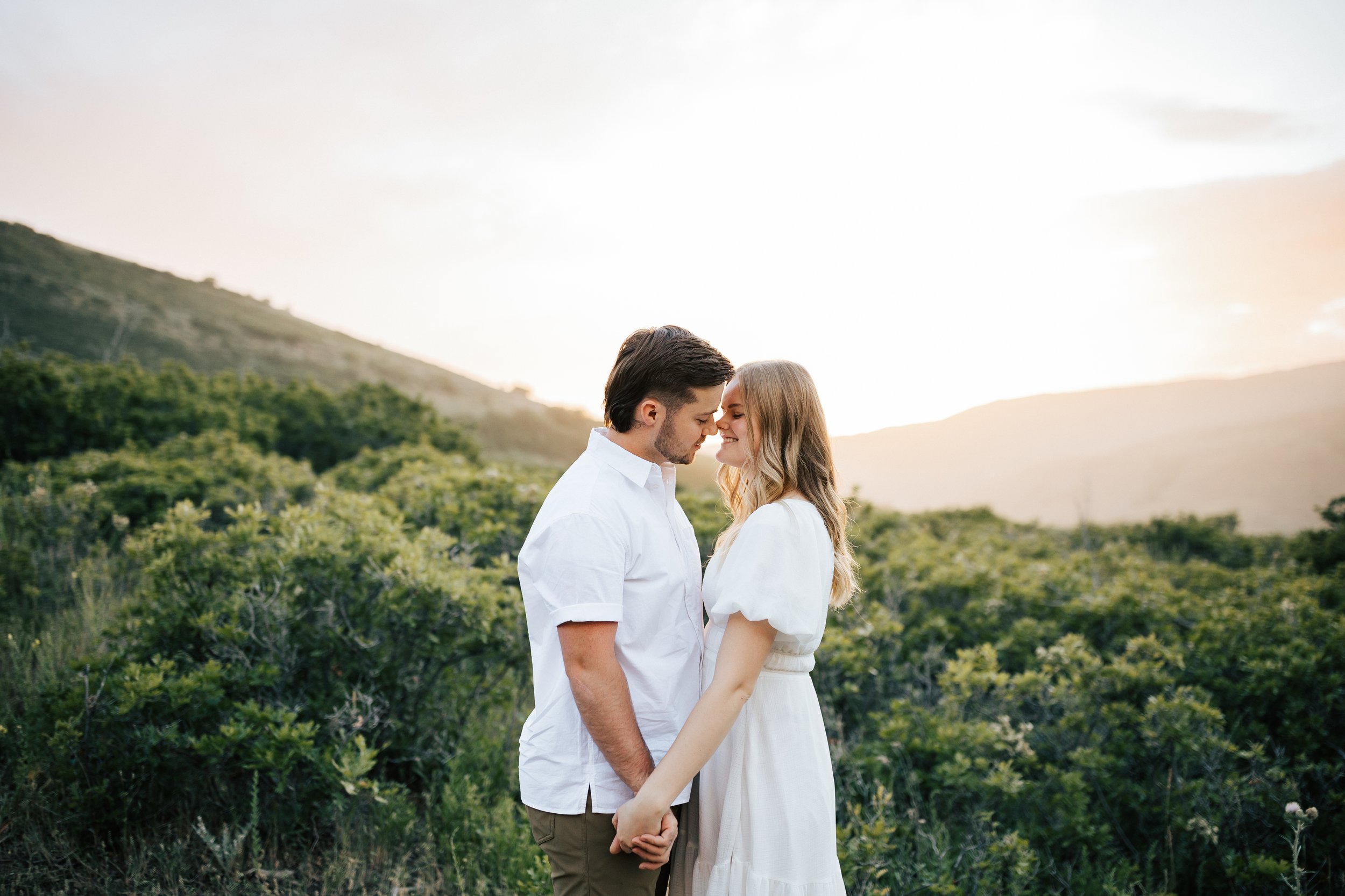  Summer anniversary couples session in the mountains. A young couple kisses with the sun glowing behind them during golden hour. Utah photographer. #utahphotographer #utahengagements  