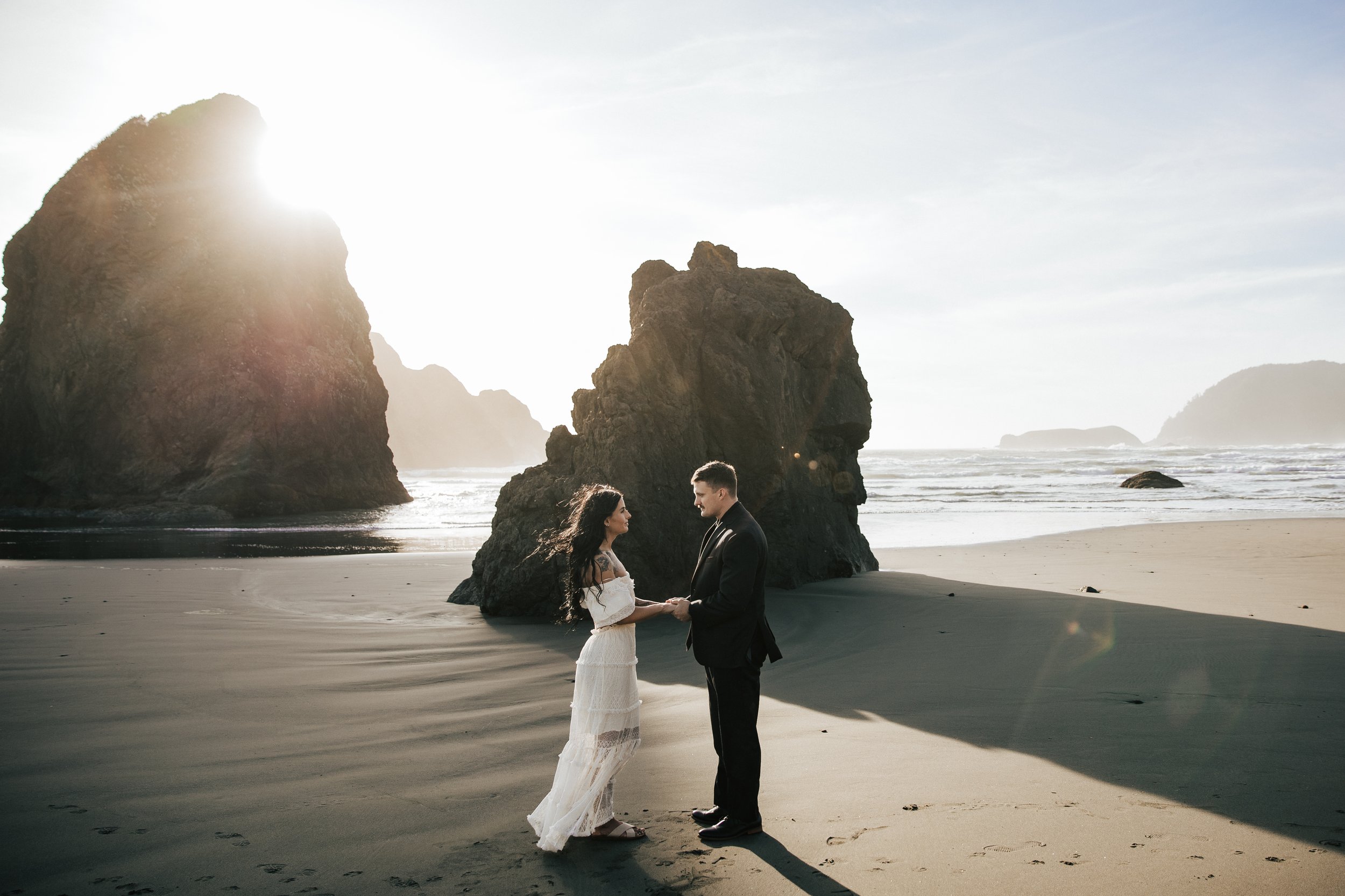  Oregon coast elopement. Couple elopes on the beach with the sun shining behind them. Sun rays behind rocks. Beach with rocks and haystacks. Southern Oregon. Brookings, Oregon. Samuel H Boardman elopement. #oregon #photographer #elopement 