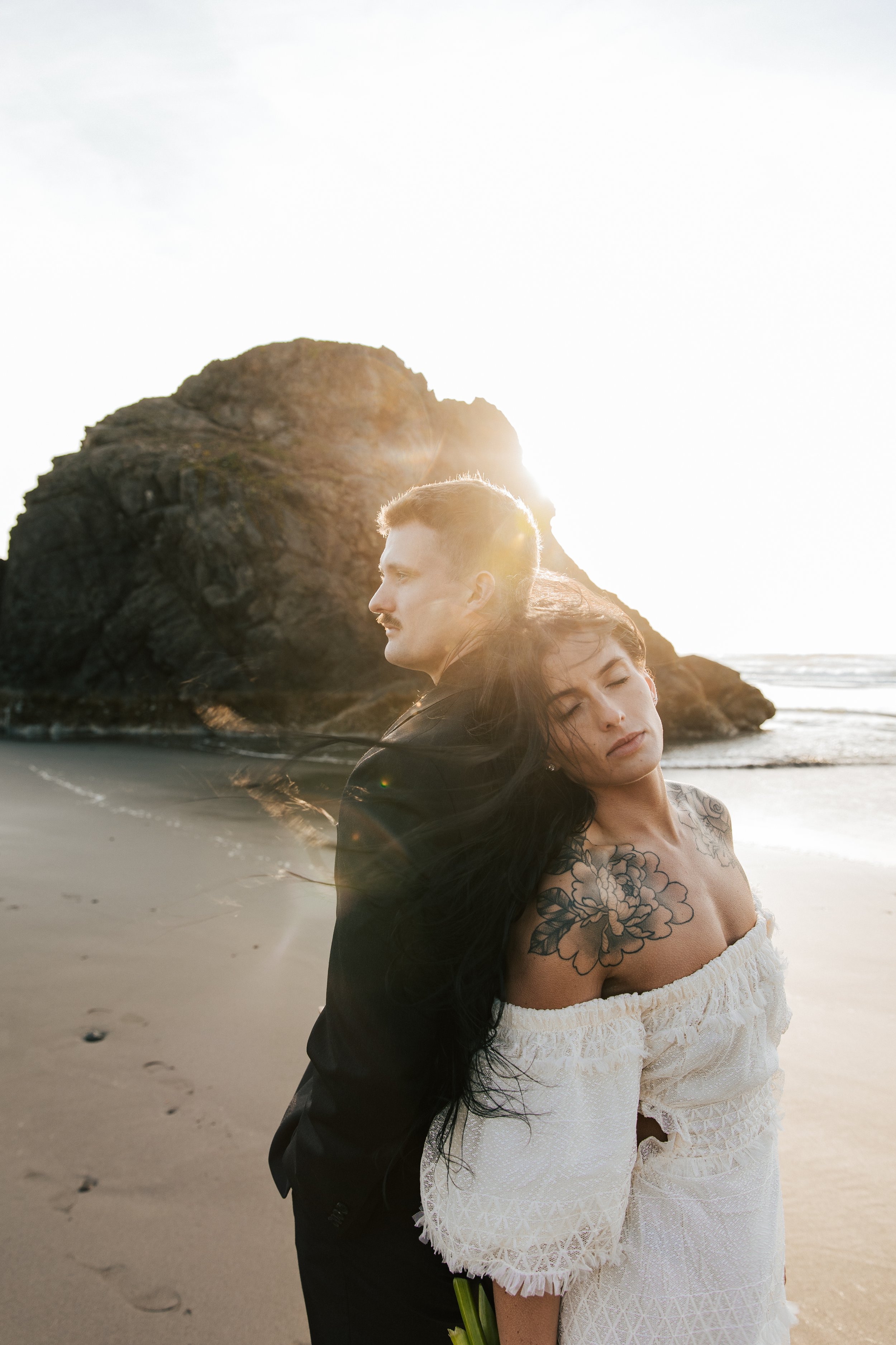  Oregon coast elopement. Couple elopes on the beach with the sun shining behind them. Sun rays behind rocks. Beach with rocks and haystacks. Southern Oregon. Brookings, Oregon. Samuel H Boardman elopement. #oregon #photographer #elopement   