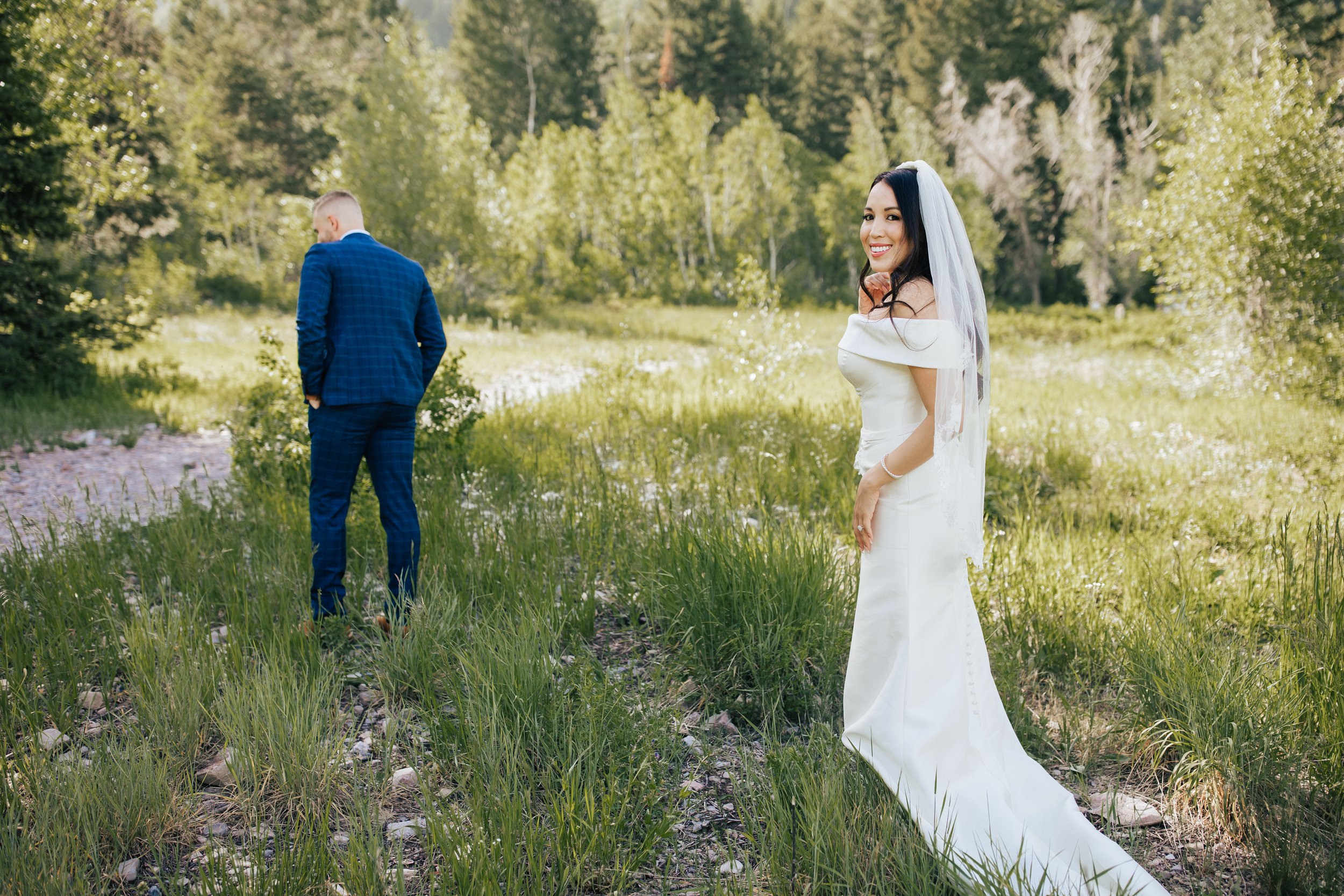  First look photo session with bride and groom in Aspen Grove, Provo Canyon, Utah. Groom waits for his bride to show off her beautiful wedding dress. 