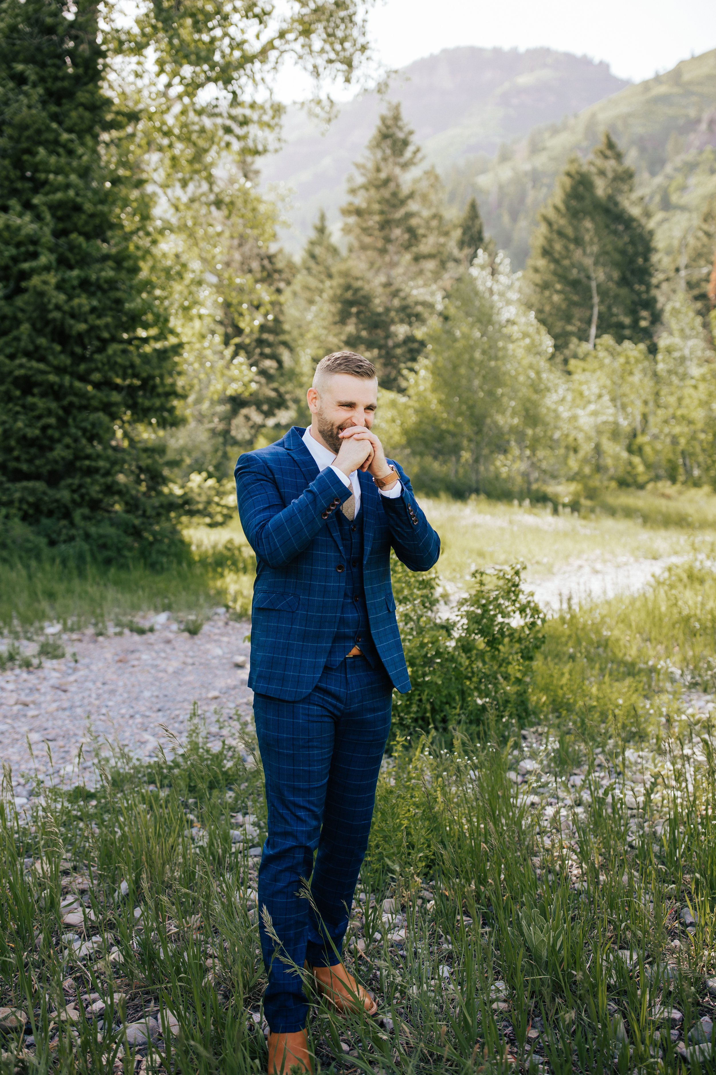  Groom reacts excitedly to seeing his bride for the first time in her wedding dress during first look session. Provo Canyon, Utah. 