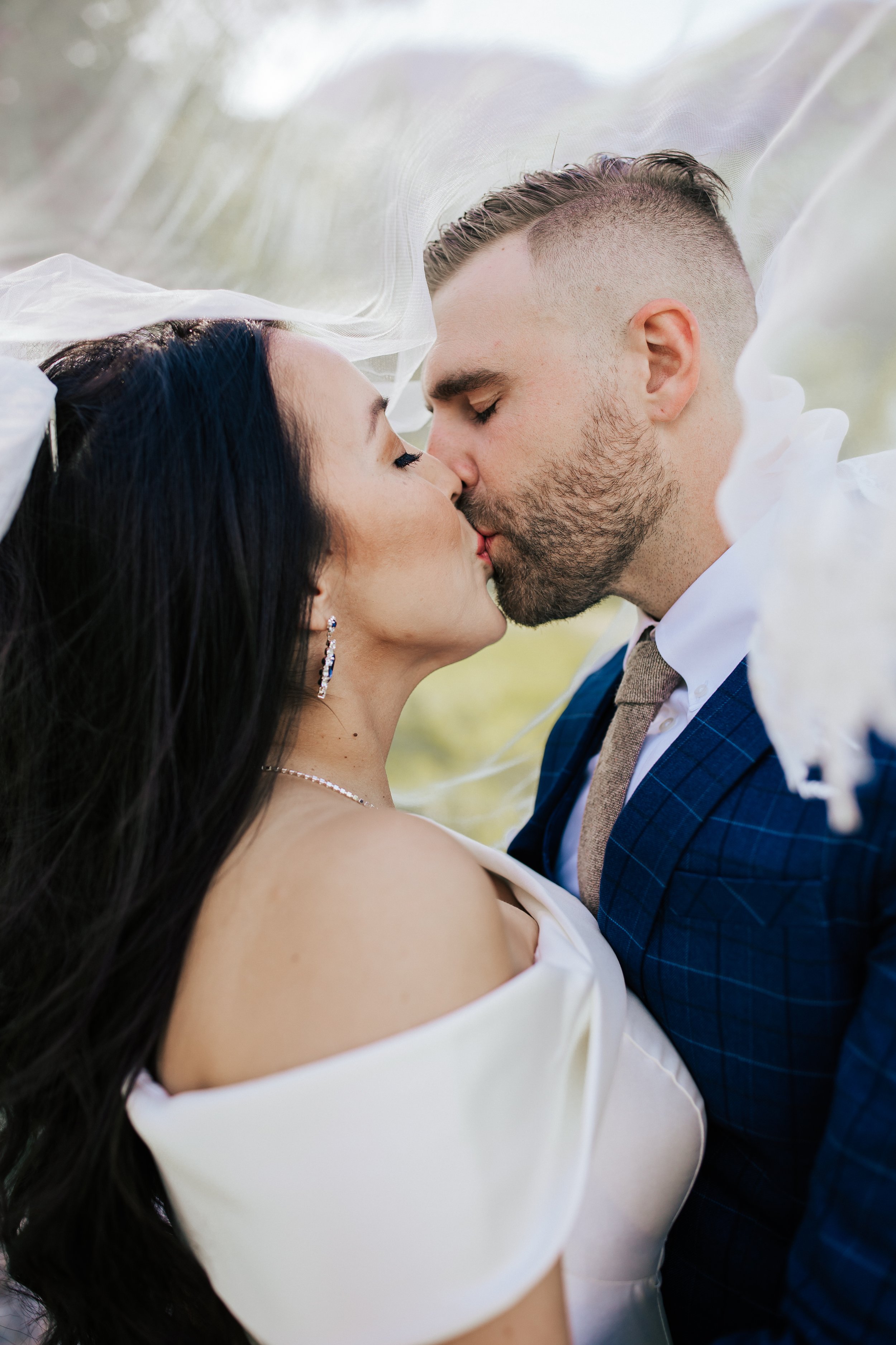  Bride and groom kiss under her wedding veil. First look session with bride and groom before their wedding ceremony in Aspen Grove, Provo Canyon, Utah. #weddingdress #firstlook #bridalportraits 