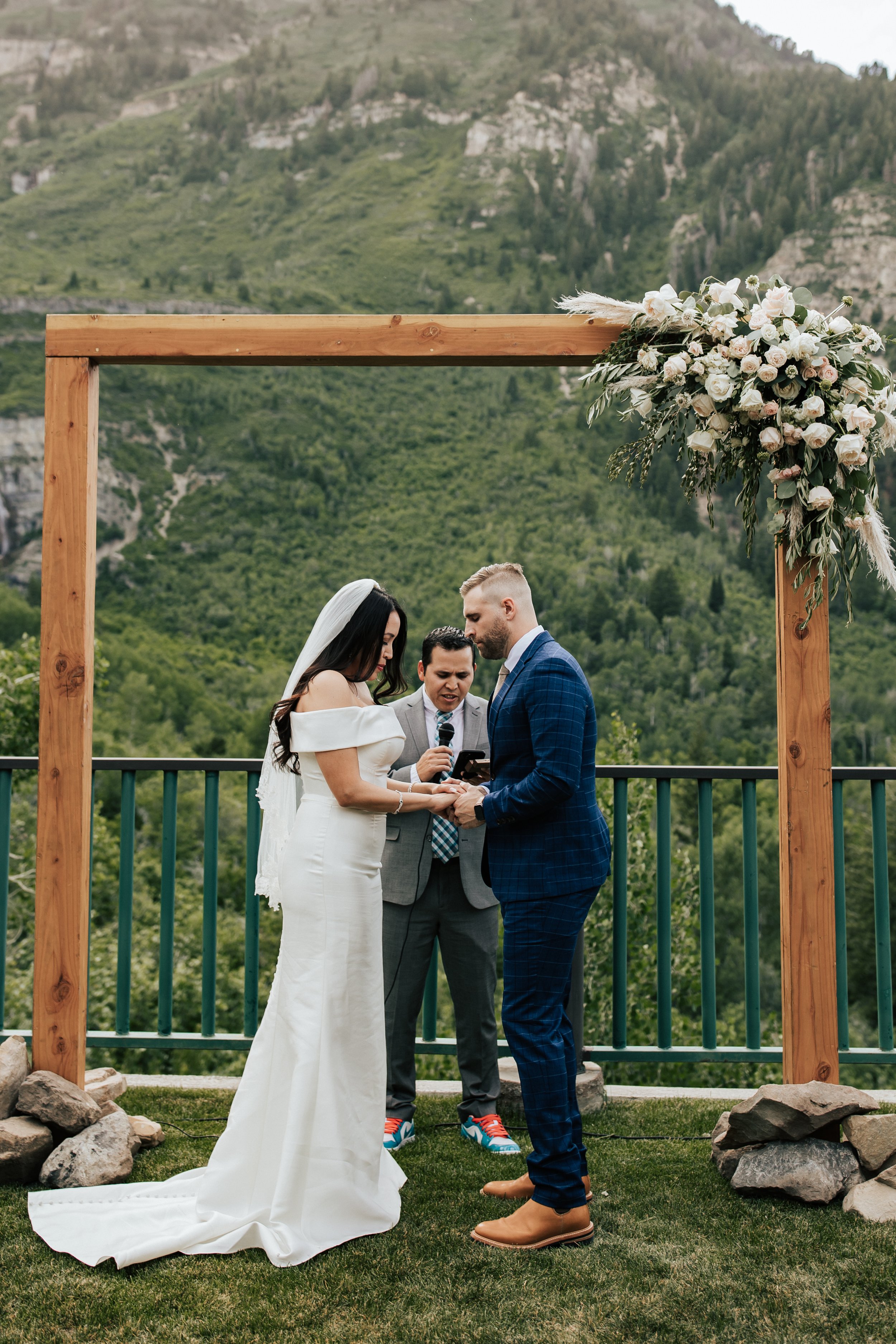  Couple praying together during wedding ceremony. Sundance, Utah wedding ceremony with the sun setting behind Mt. Timpanogos and Stewart Falls in view. Beautiful summer wedding in Provo, Utah with green mountains behind. #utahwedding #weddingceremony