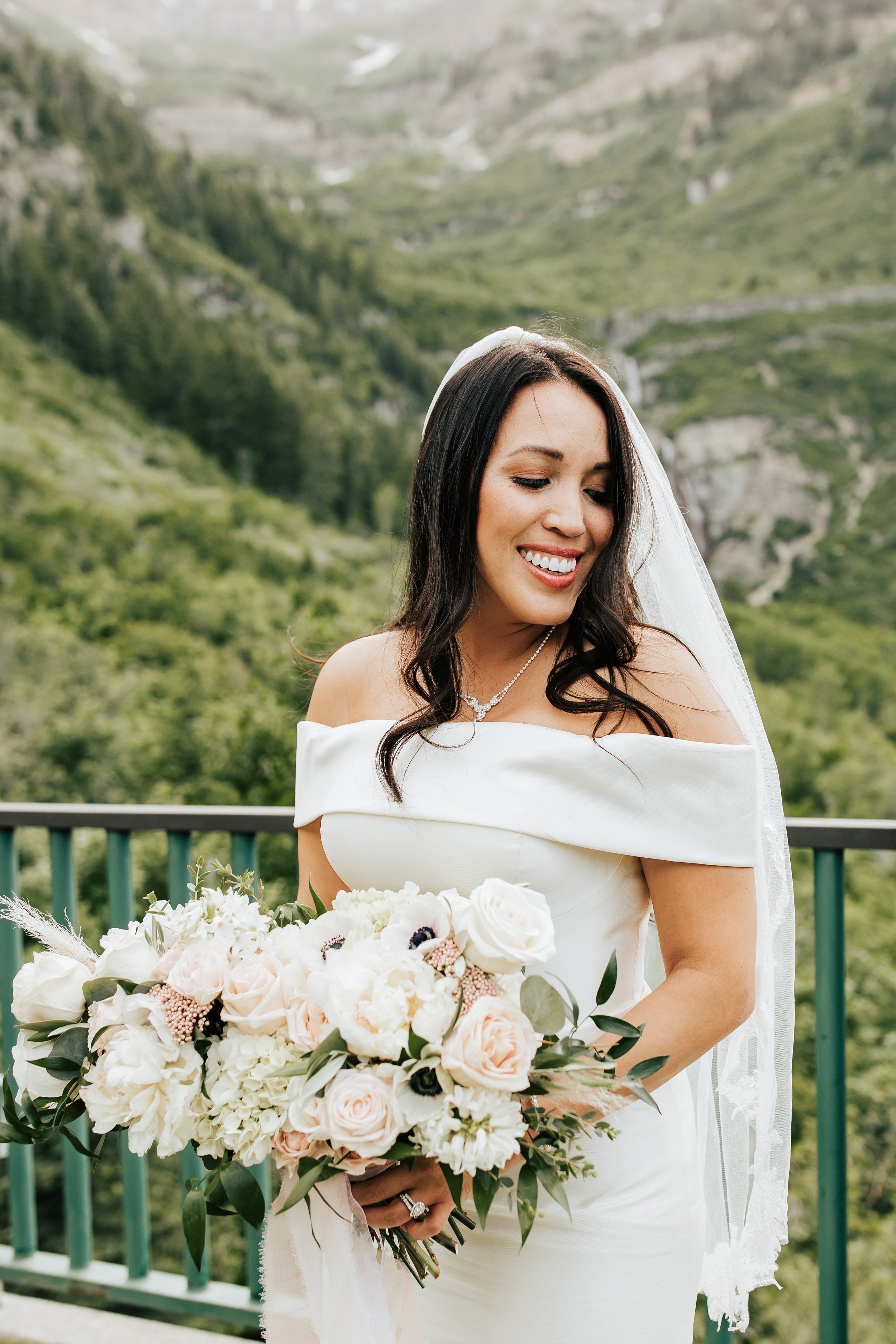  Bride smiles while holding her large pink and white bouquet of flowers after wedding ceremony. #weddingphotos #weddingphotographer #utahwedding 