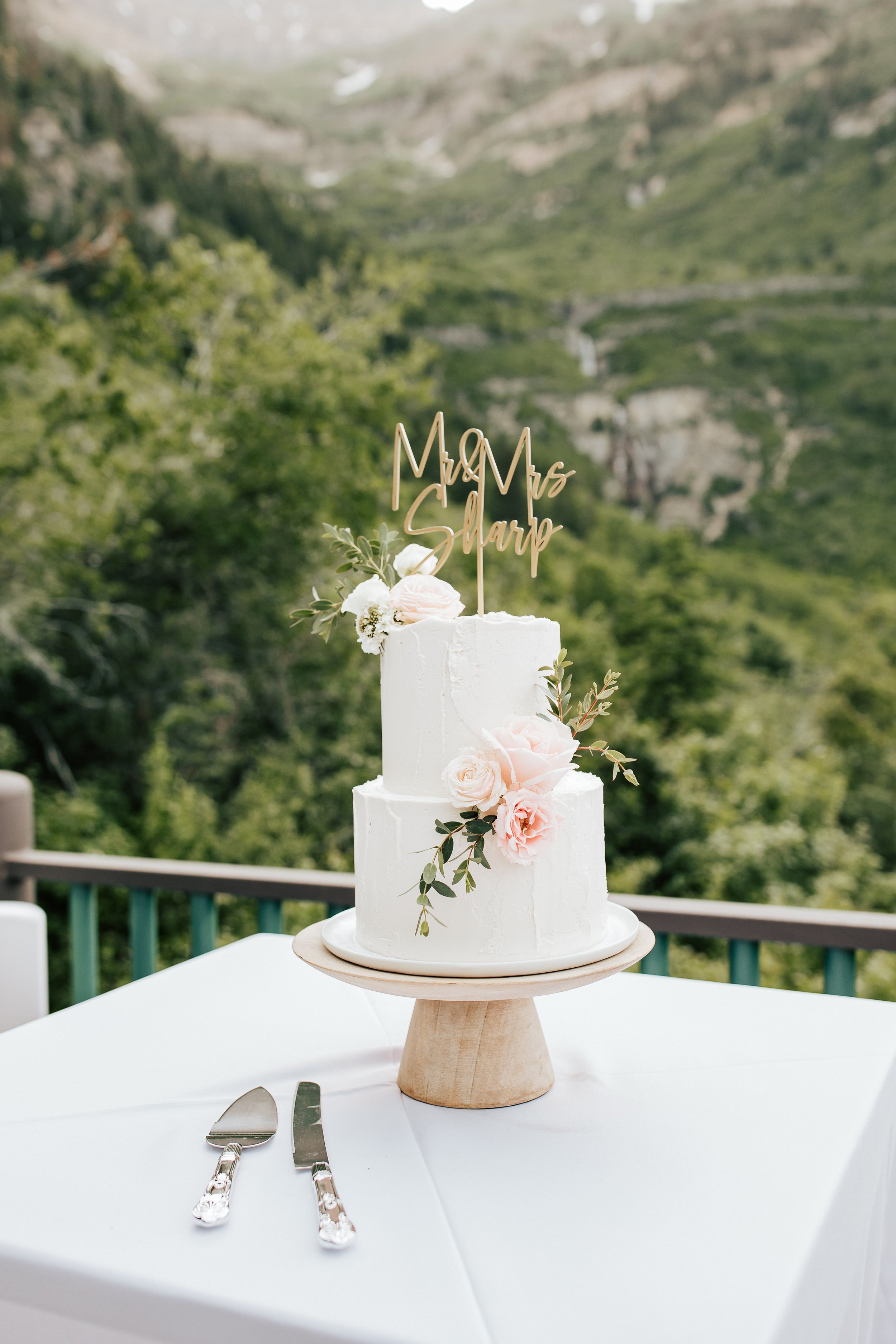  Couple cuts wedding cake together. Beautiful two tier wedding cake with flowers. #weddingcake #weddingphotos #utahwedding 