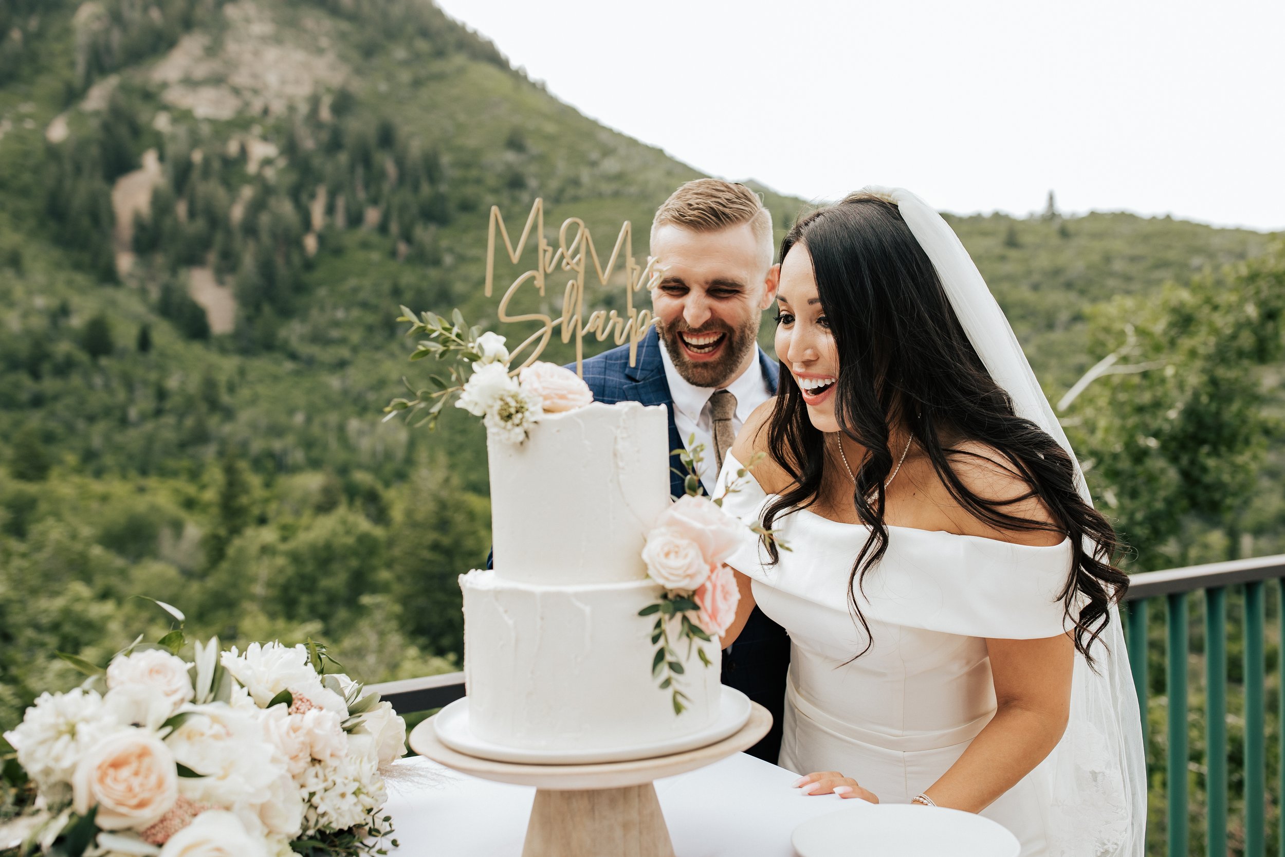  Couple cuts wedding cake together. Beautiful two tier wedding cake with flowers. #weddingcake #weddingphotos #utahwedding 