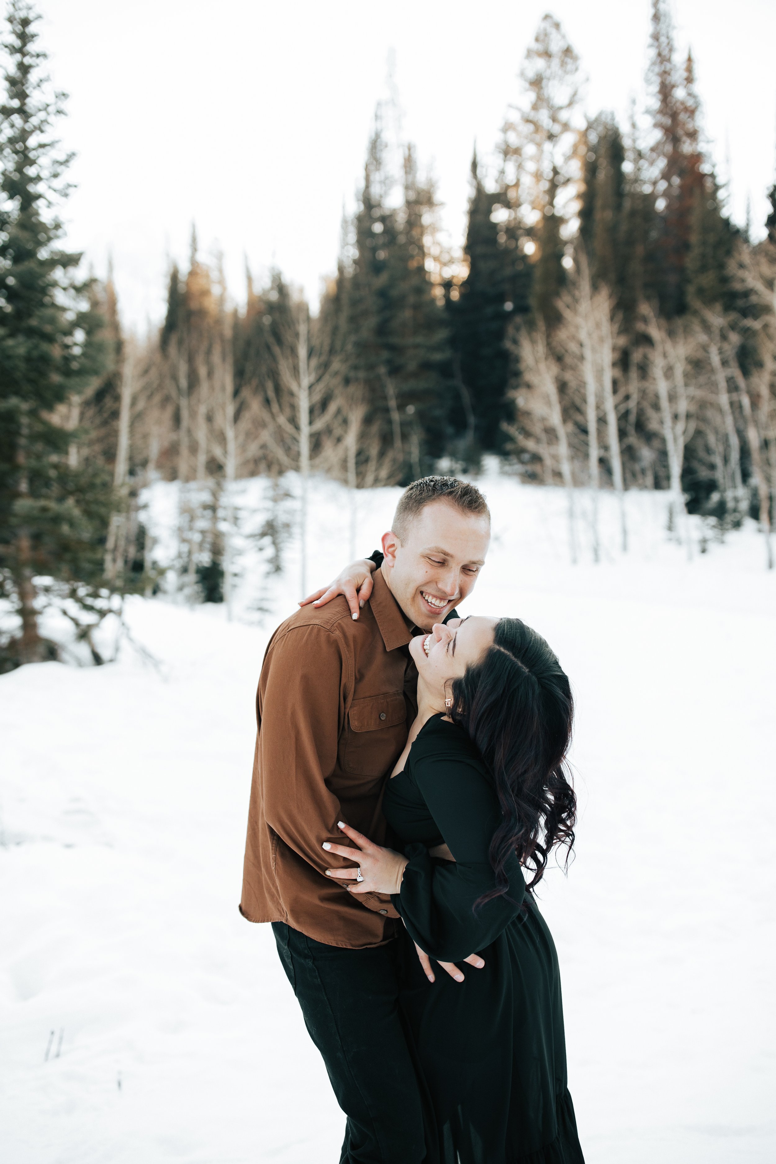  Winter photoshoot outfit inspo. Man and woman kiss in the snowy mountains wearing coats and beanies. Utah mountain engagement shoot in the winter. Park City, Utah photographer. #winter #engagements #engagementsession #utahphotoshoot #utahengagements