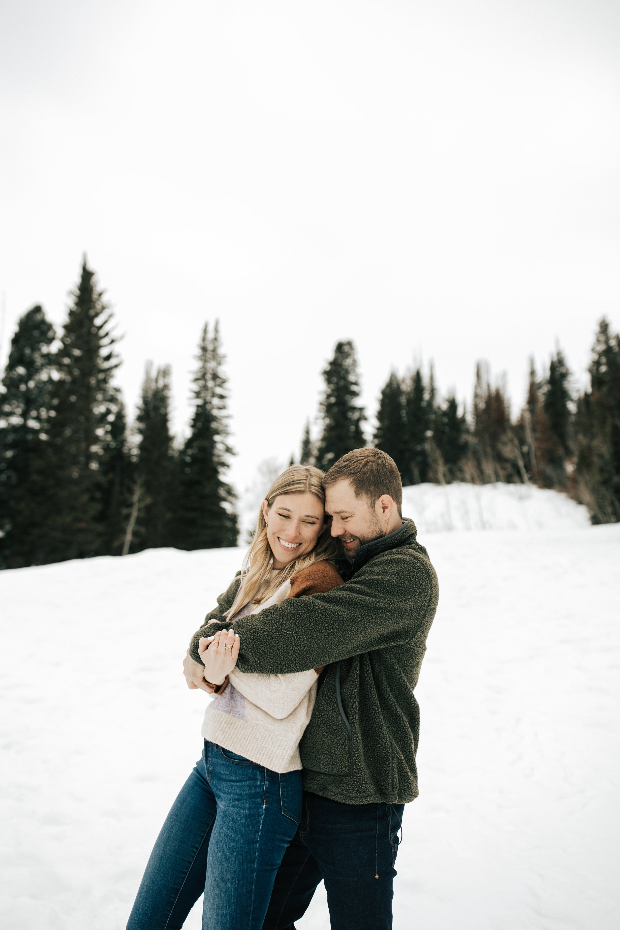  Winter photoshoot outfit inspo. Man and woman kiss in the snowy mountains wearing coats and beanies. Utah mountain engagement shoot in the winter. Park City, Utah photographer. #winter #engagements #engagementsession #utahphotoshoot #utahengagements