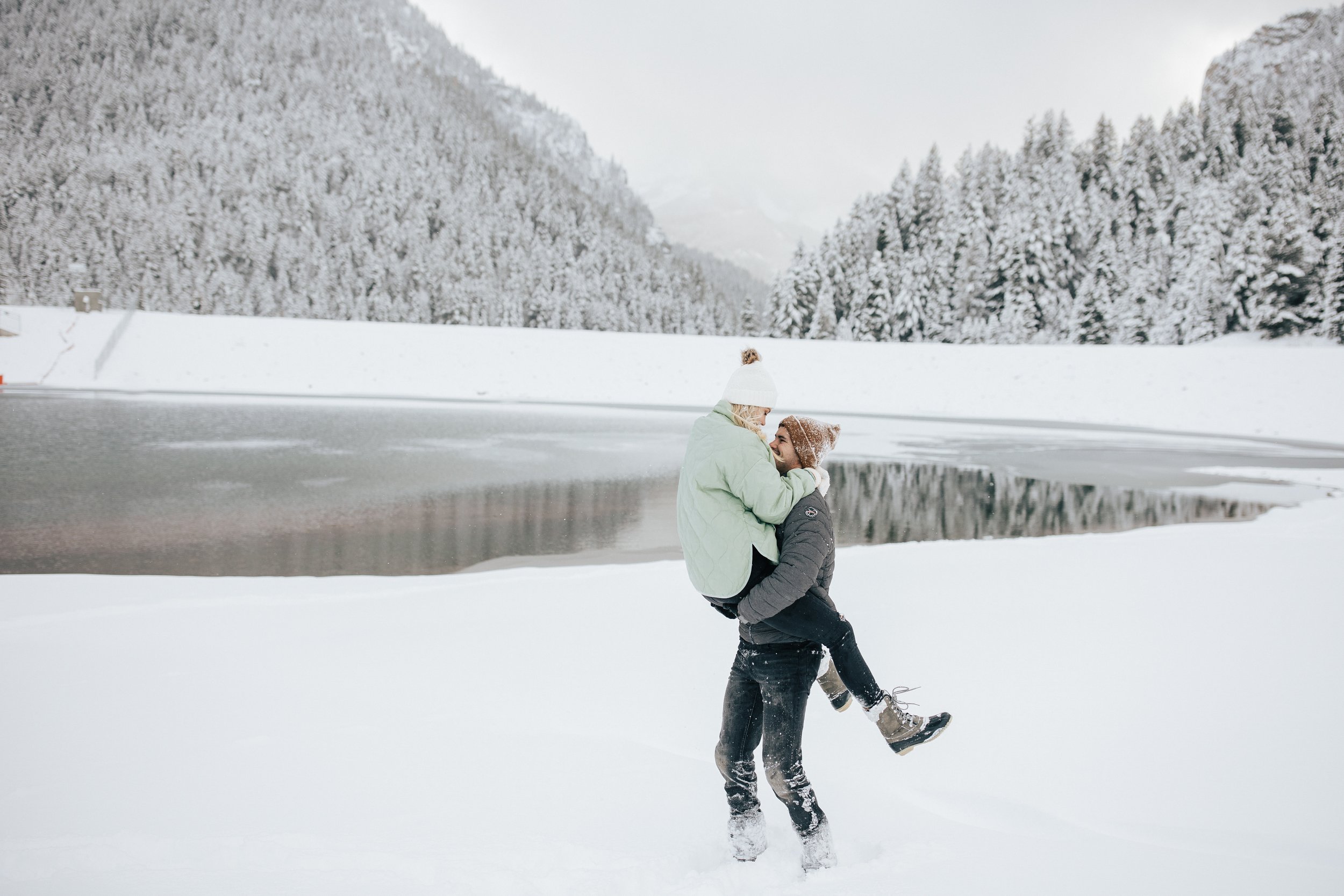  Winter photoshoot outfit inspo. Man and woman play in the snow in the Utah mountains wearing coats and beanies. Utah mountain engagement shoot in the winter. Park City, Utah photographer. #winter #engagements #engagementsession #utahphotoshoot #utah