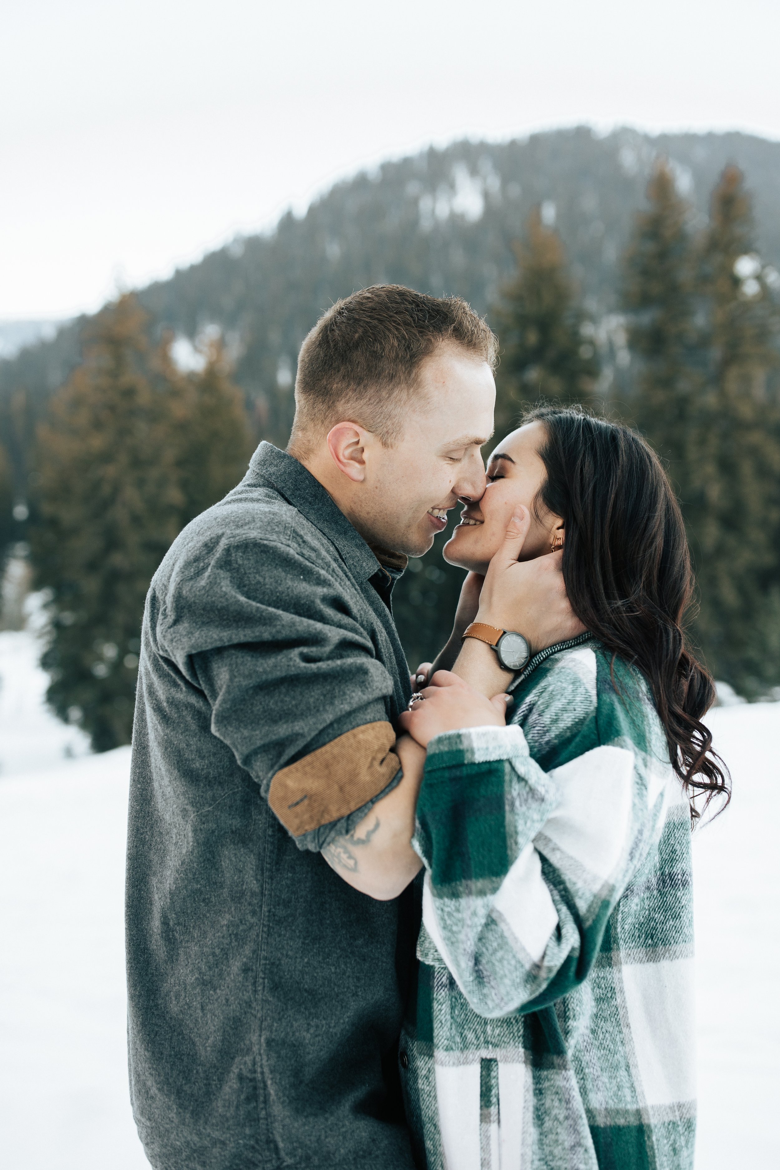  Winter photoshoot outfit inspo. Man and woman kiss in the snowy mountains. Utah mountain engagement shoot in the winter. Park City, Utah photographer. #winter #engagements #engagementsession #utahphotoshoot #utahengagements 