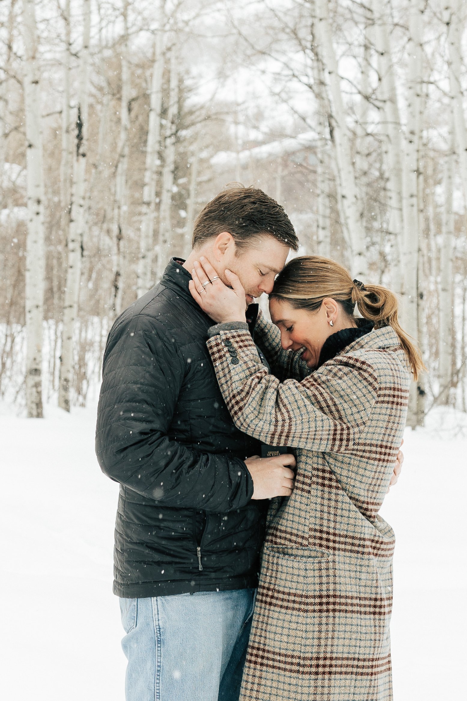  Newly engaged couple hug after surprise proposal. Winter engagement session in Park City, Utah. Boyfriend surprises girlfriend with wedding proposal during a snowy photoshoot. Man proposes to girlfriend. #parkcity #engagements #engagementsessionn #p
