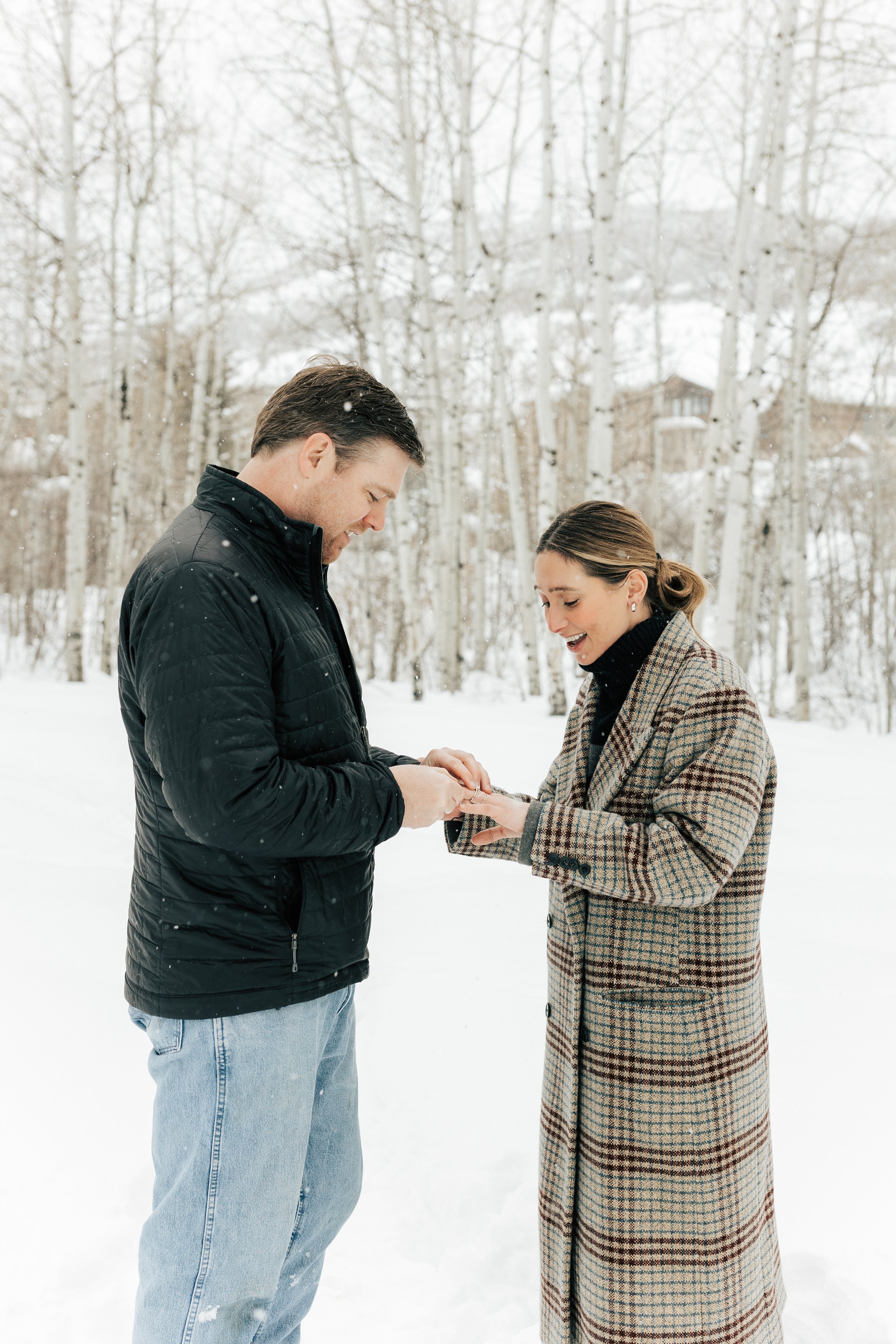  Newly engaged man puts engagement ring on fiancé’s finger. Winter engagement session in Park City, Utah. Boyfriend surprises girlfriend with wedding proposal during a snowy photoshoot. Man proposes to girlfriend. #parkcity #engagements #engagementse