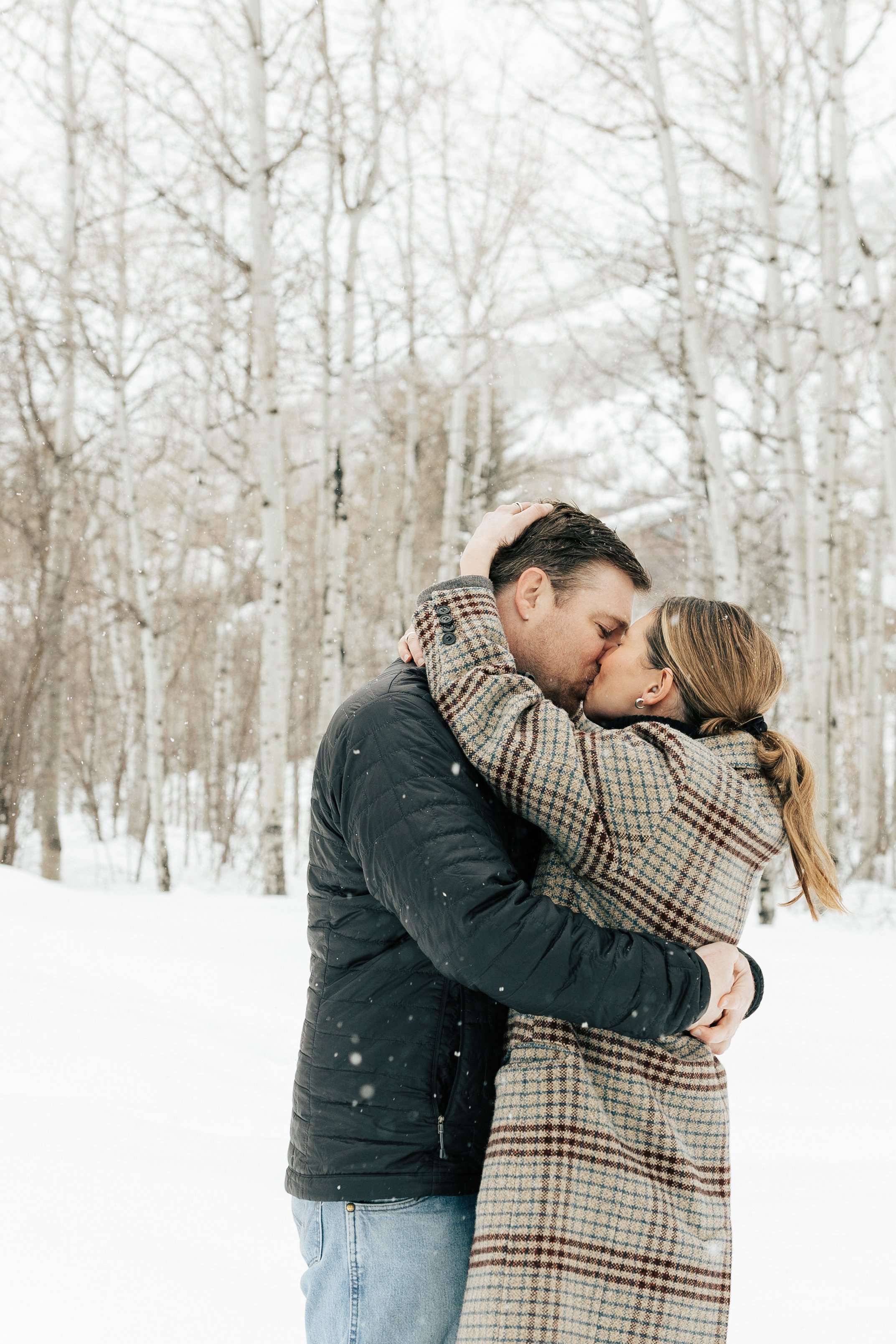  Newly engaged couple kiss. Winter engagement session in Park City, Utah. Boyfriend surprises girlfriend with wedding proposal during a snowy photoshoot. Man proposes to girlfriend. #parkcity #engagements #engagementsessionn #proposal 
