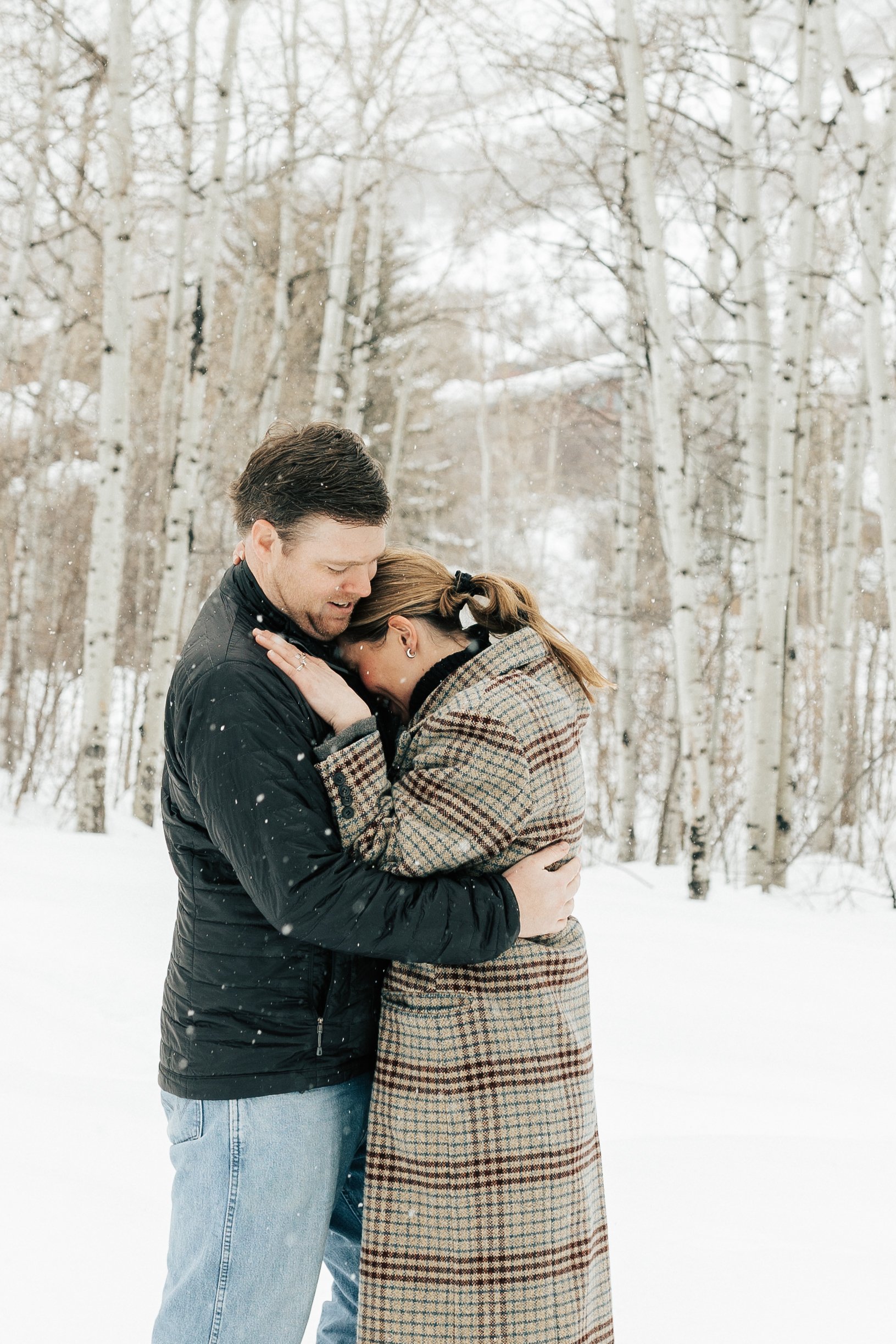  Newly engaged couple hug. Winter engagement session in Park City, Utah. Boyfriend surprises girlfriend with wedding proposal during a snowy photoshoot. Man proposes to girlfriend. #parkcity #engagements #engagementsessionn #proposal 