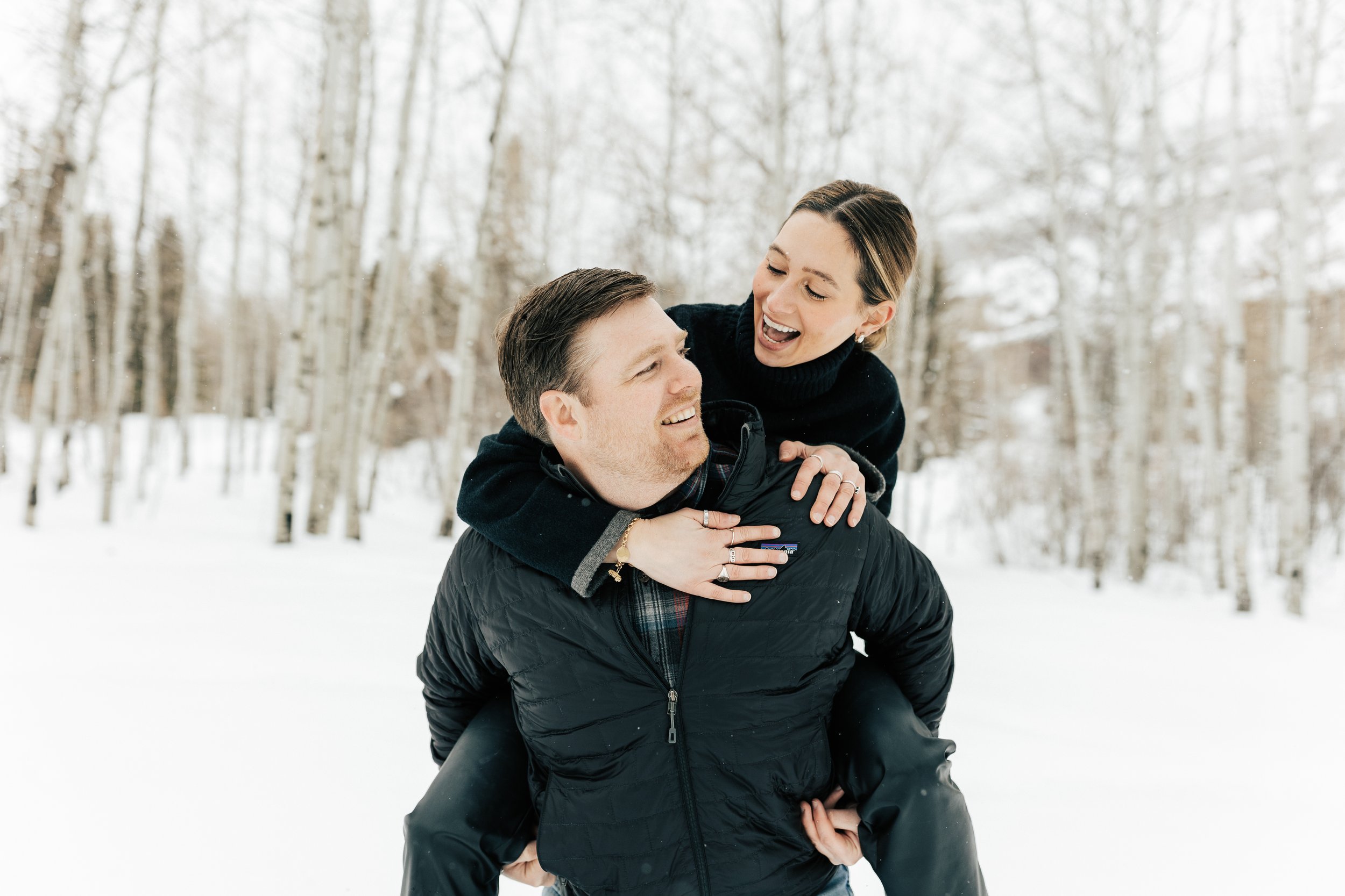  Man gives fiance piggy back ride. Winter engagement session in Park City, Utah. Boyfriend surprises girlfriend with wedding proposal during a snowy photoshoot. Man proposes to girlfriend. #parkcity #engagements #engagementsessionn #proposal 