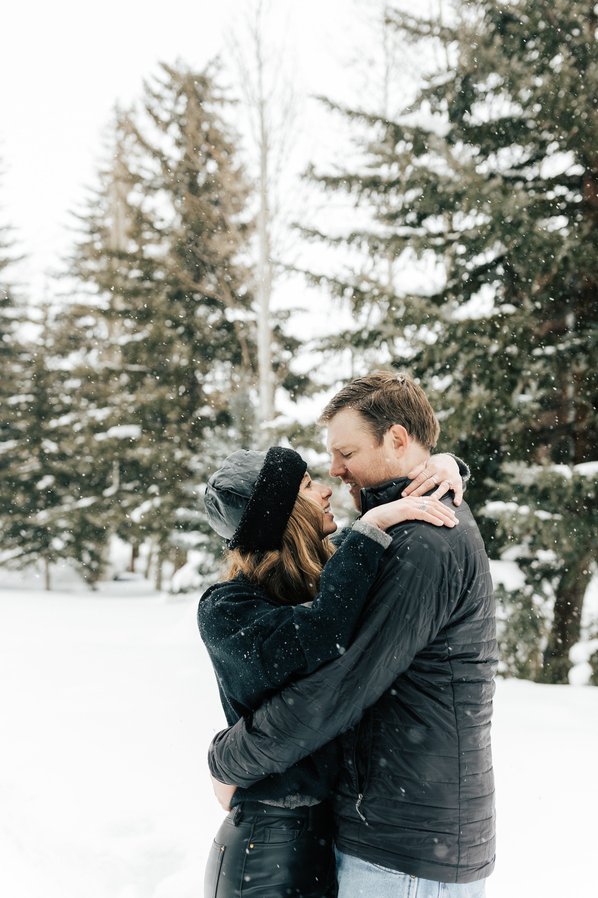  Newly engaged couple kiss. Winter engagement session in Park City, Utah. Boyfriend surprises girlfriend with wedding proposal during a snowy photoshoot. Man proposes to girlfriend. Winter couple outfit inspo. #parkcity #engagements #engagementsessio