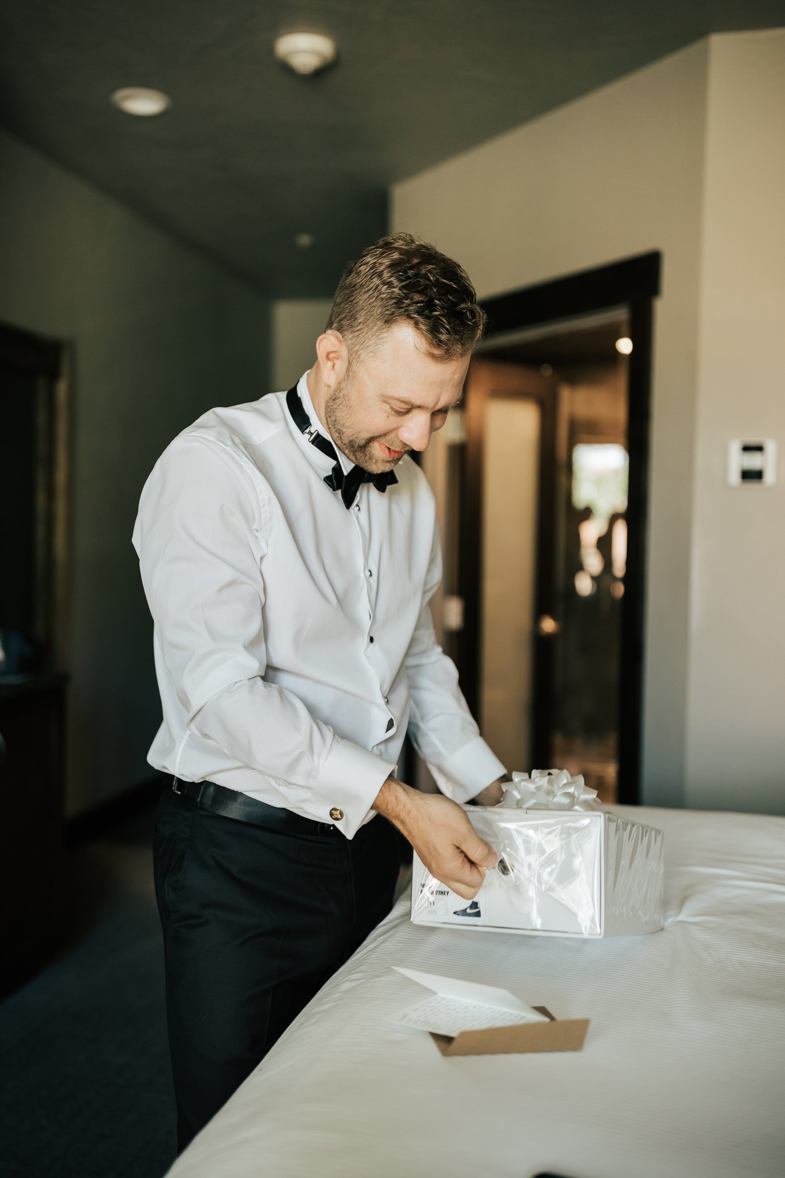  Getting ready photos. Groom gets ready in hotel room before wedding. Groomsman helps groom get ready. #montanawedding #utahwedding #gettingreadyphotos 
