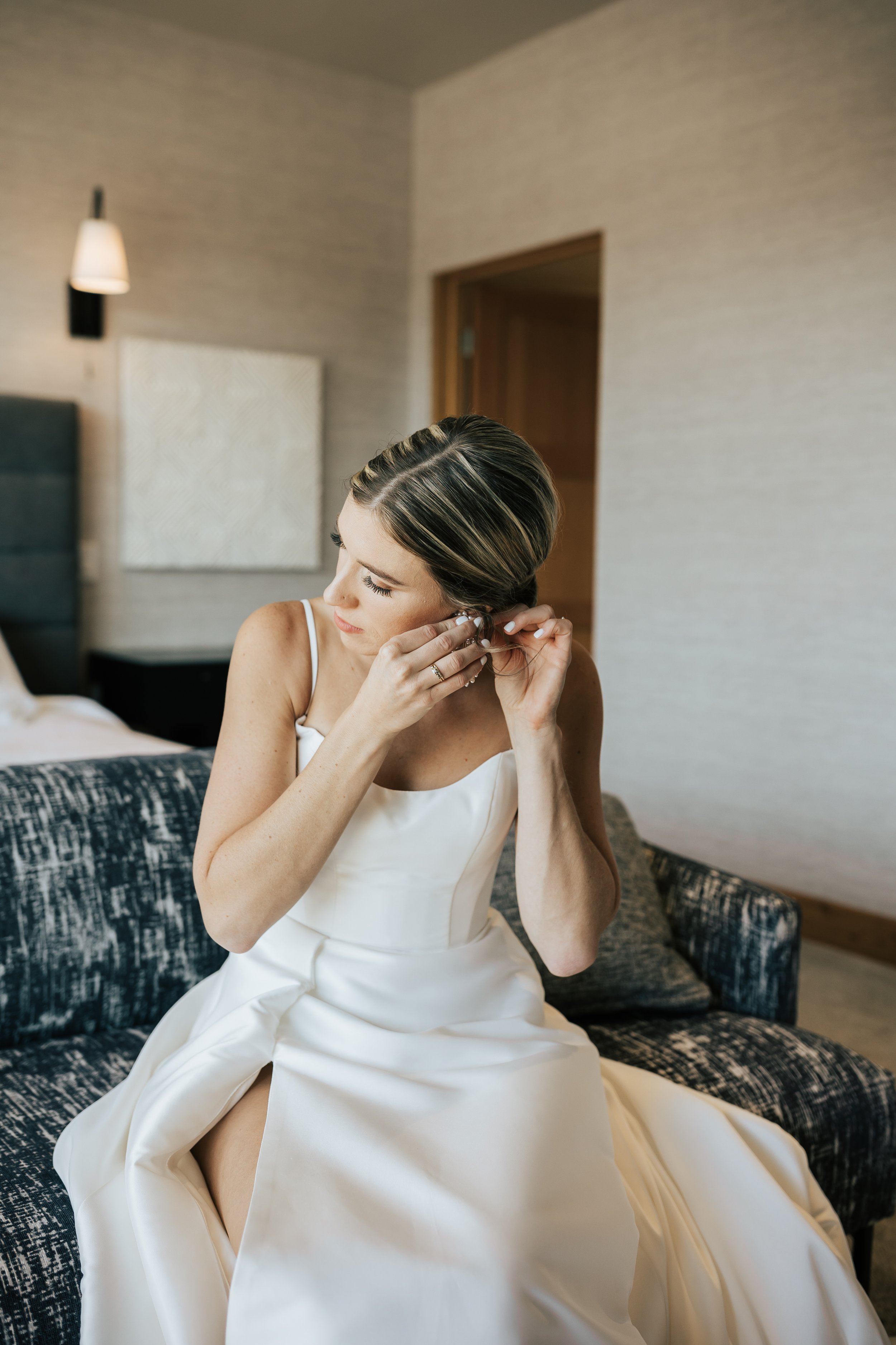  Getting ready photos. Bride gets ready in hotel room before wedding. Bride putting on her earrings before ceremony. #montanawedding #utahwedding #gettingreadyphotos 