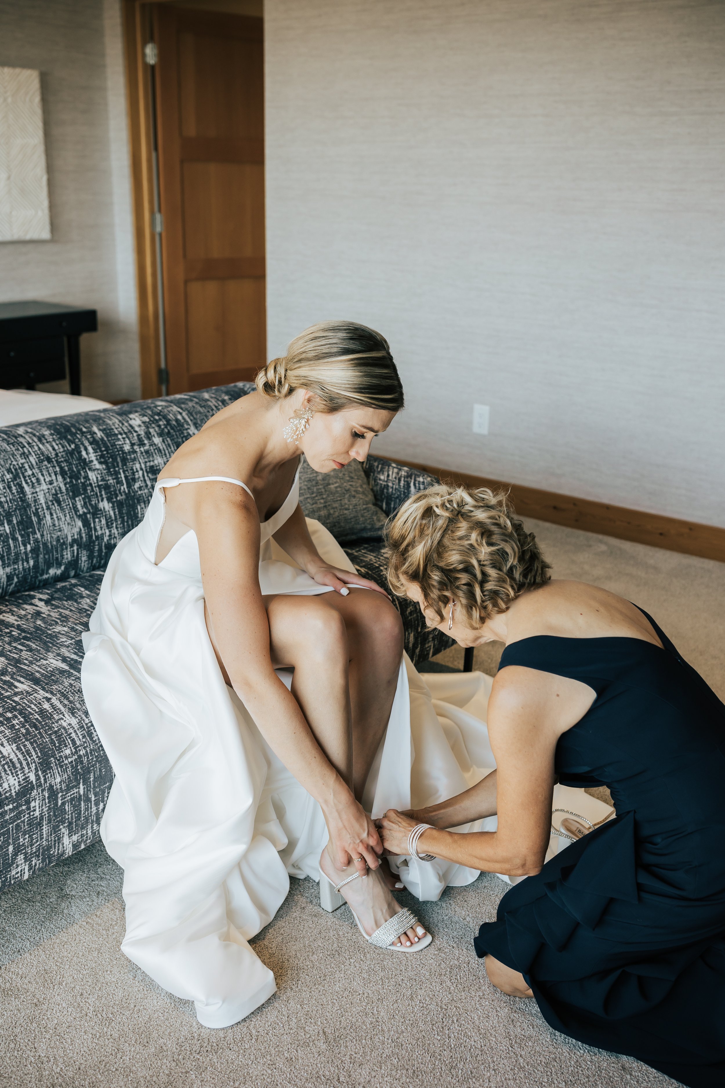  Bride’s mom helps her put on her wedding shoes before the ceremony. Wedding getting ready photos. #weddingphotography #montanawedding 