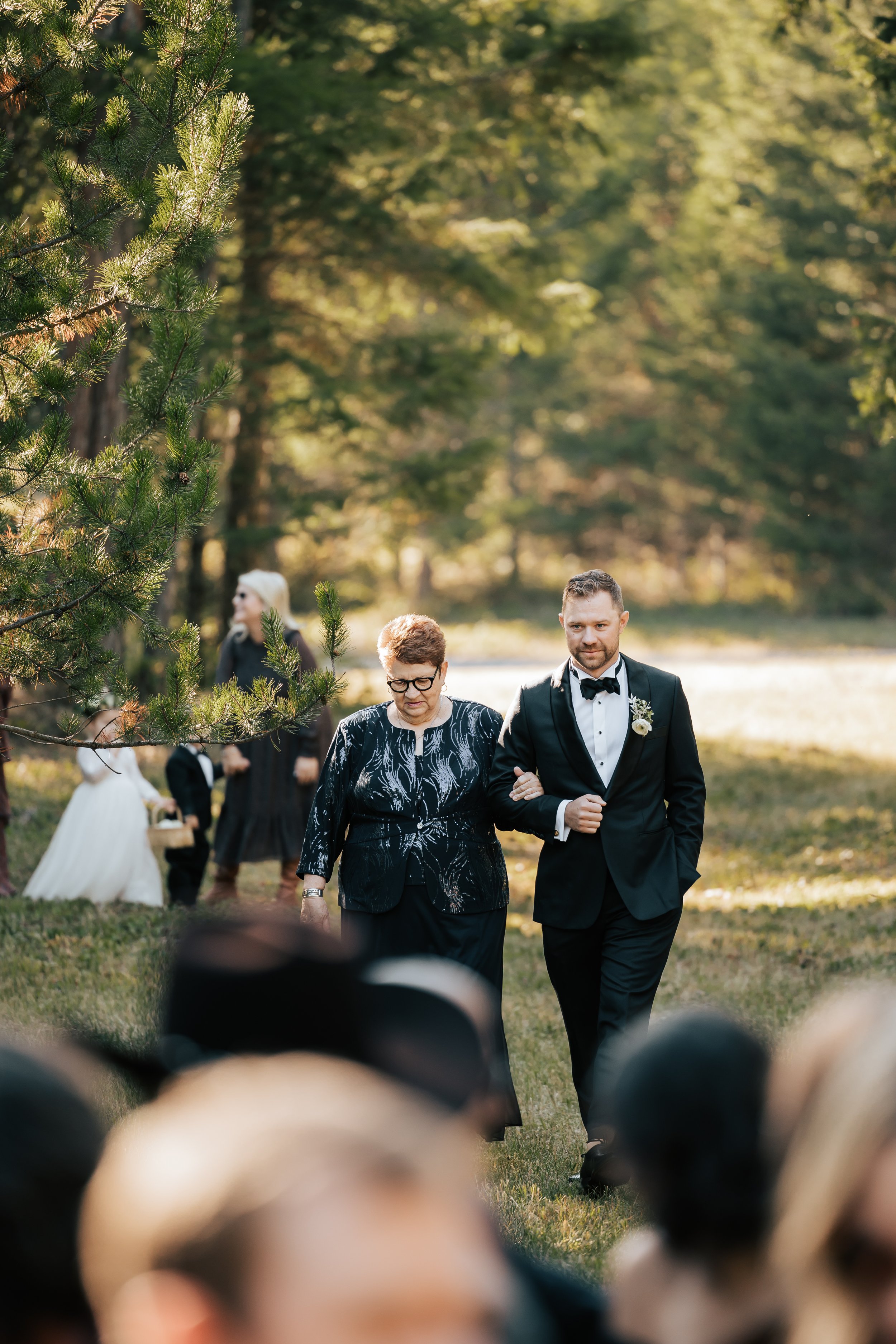  Groom walks down aisle with his mother as the wedding ceremony starts in Whitefish, Montana. Whitefish wedding. #montanawedding #weddingceremony  