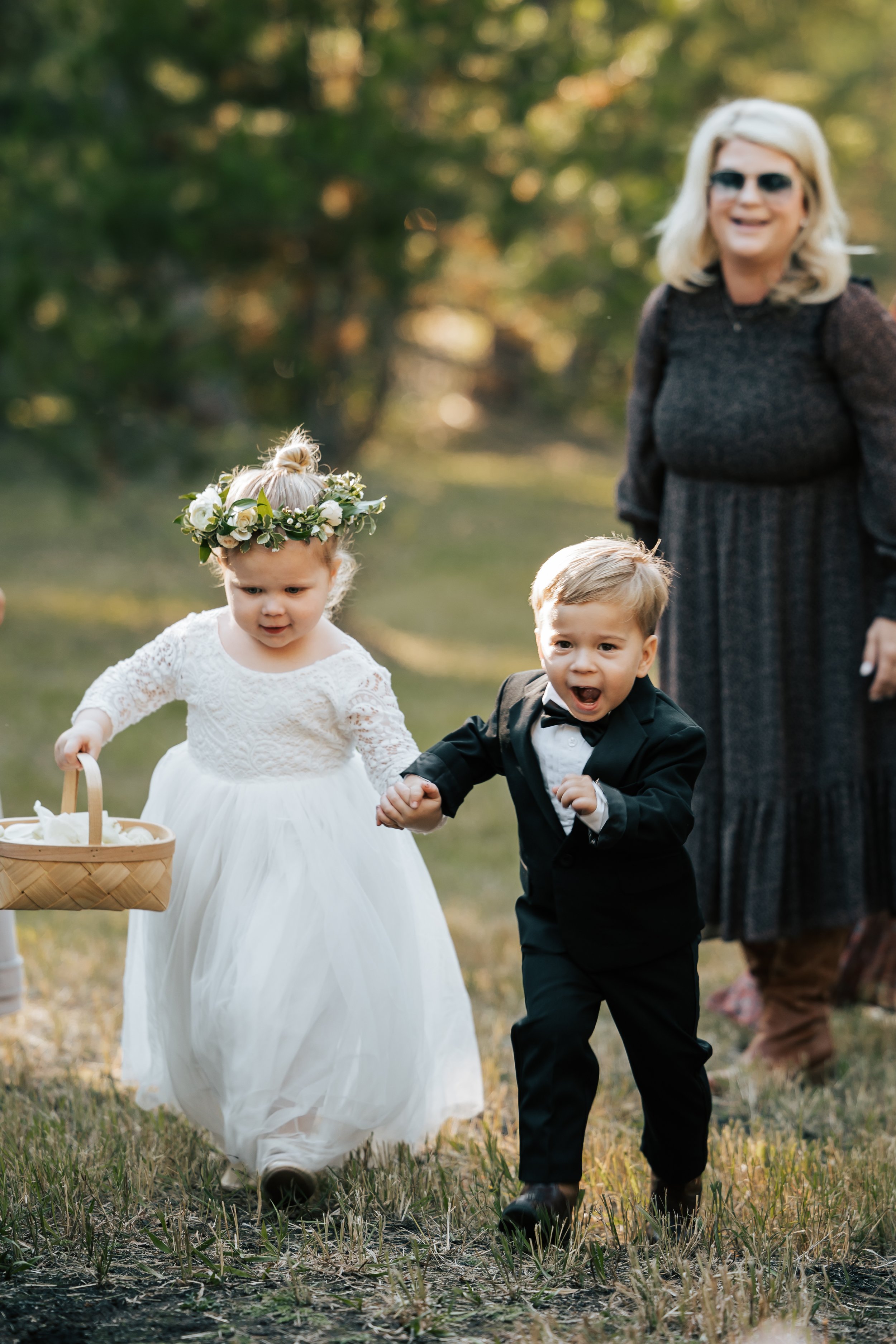  The cutest flower girl and ring bearer run down the aisle together. Wedding ceremony in Montana. 