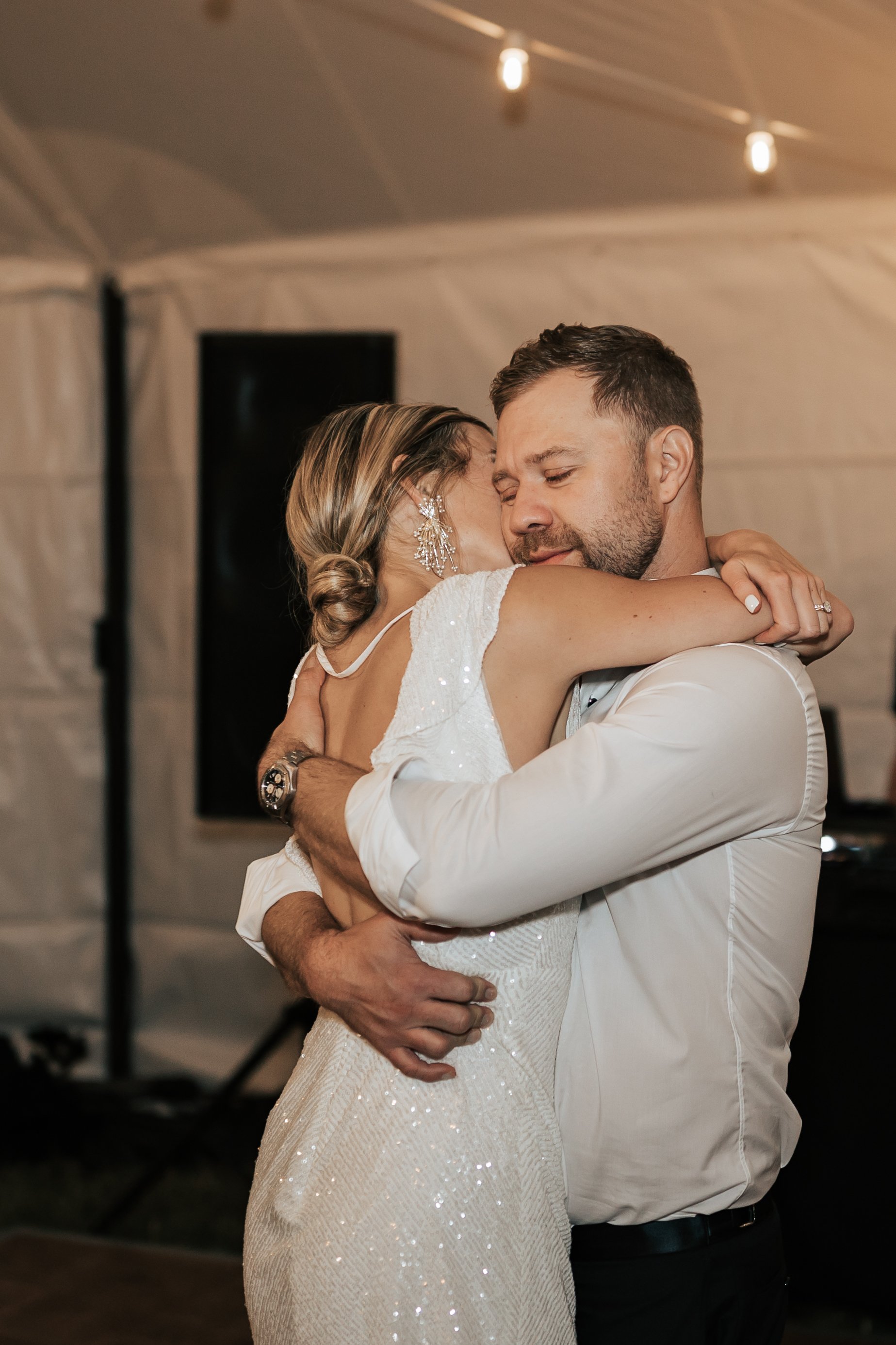  Bride and groom share a last dance together as reception ends. Bride and groom hug as they dance alone. Montana wedding photography.  