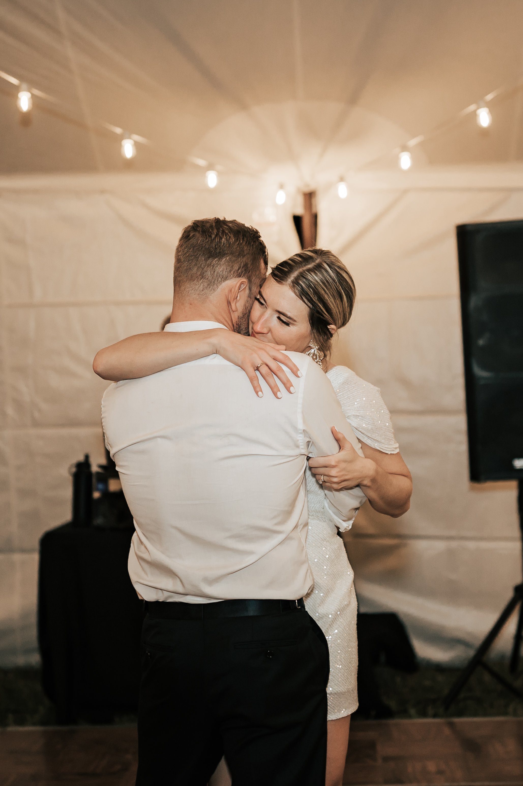  Bride and groom share a last dance together as reception ends. Bride and groom hug as they dance alone. Montana wedding photography.  