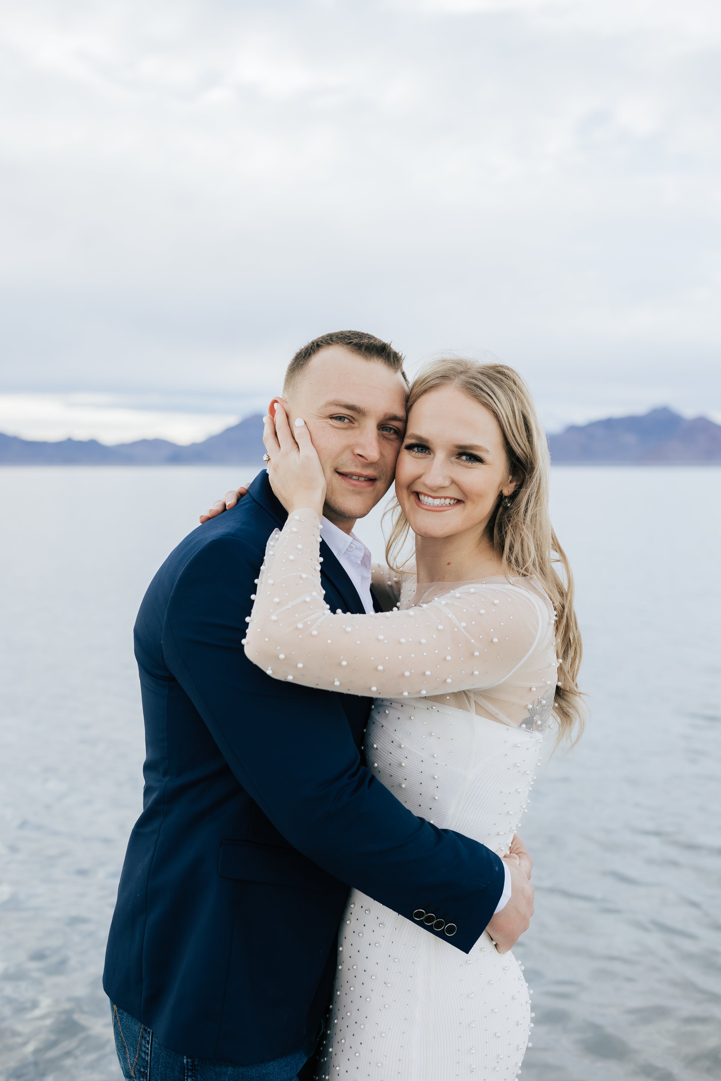 Portrait of an engaged couple holding each other while standing in the Bonneville Salt Flats by Emily Jenkins Photography. face portrait engaged pretty locations for pics in UT #EmilyJenkinsPhotography #EmilyJenkinsEngagements #BonnevilleSaltFlats #
